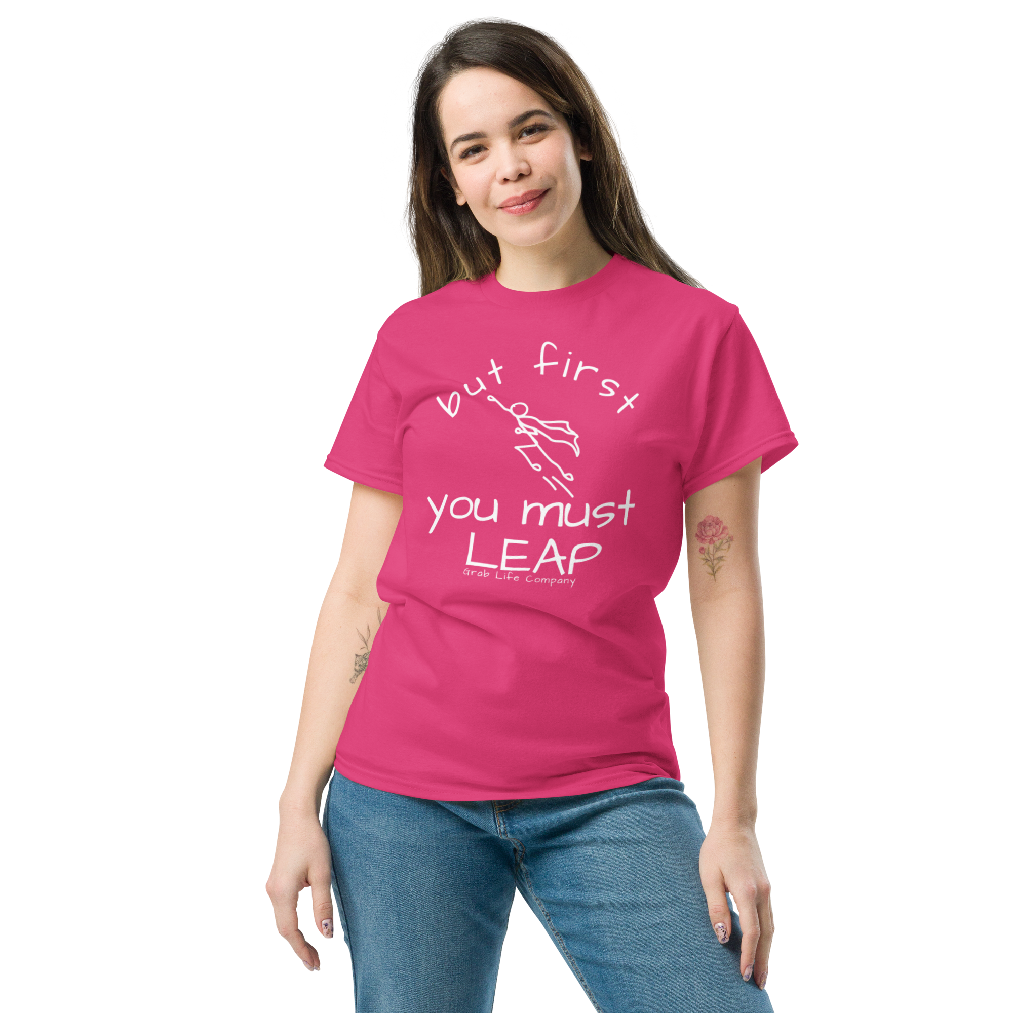 Grab Life Company t-shirt with But First You Must LEAP printed in white on front of heliconia bright pink shirt. Image shows a woman wearing the heliconia bright pink shirt.