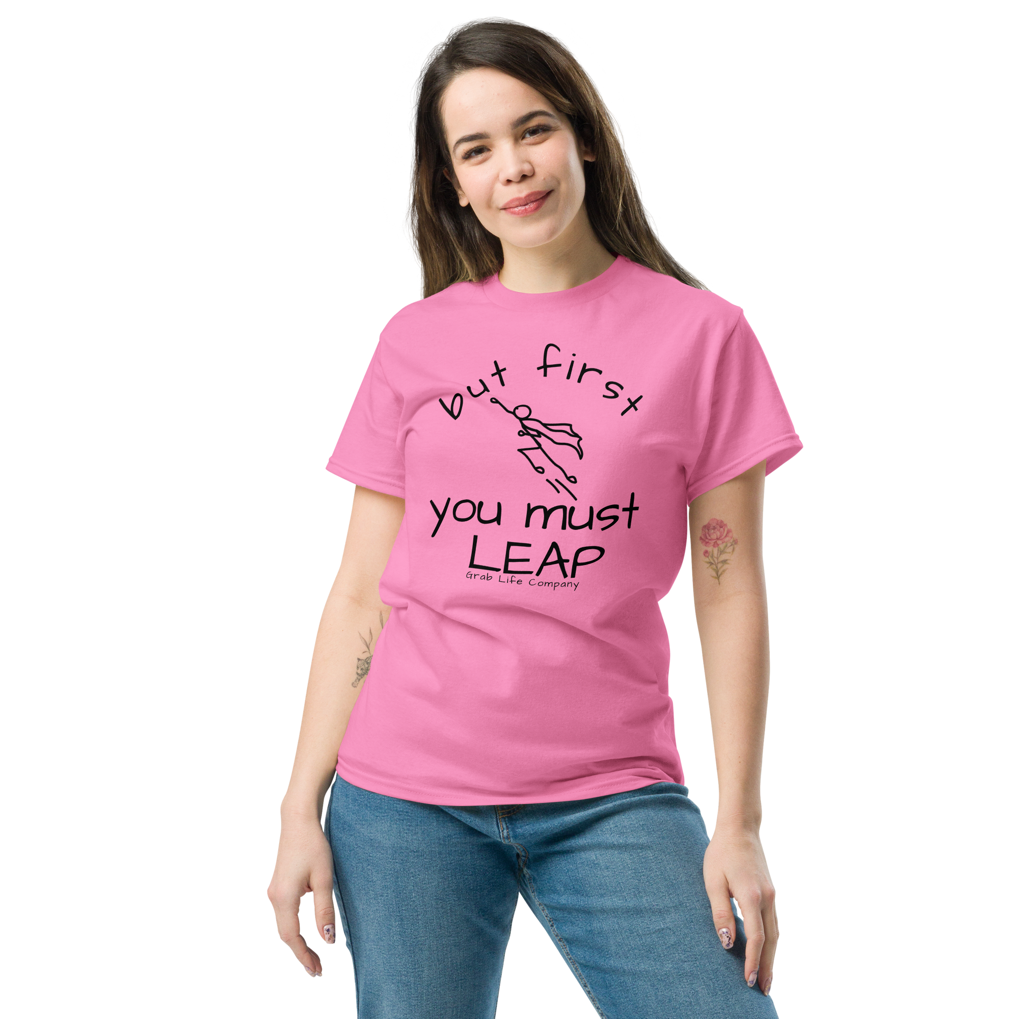 Grab Life Company t-shirt with But First You Must LEAP printed in black on front of azalea pink shirt. Image shows a woman wearing azalea pink shirt.