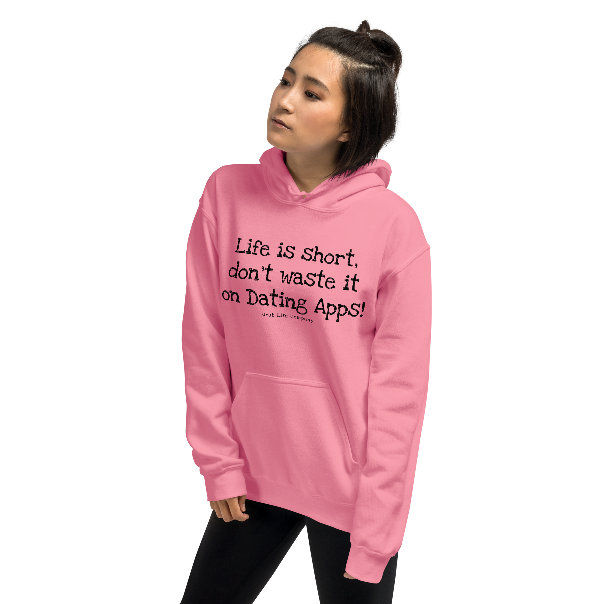 Grab Life Company unisex sweatshirt with Life is Short Don't Waste it on Dating Apps printed in black on Azalea pink hoodie. Image shows woman wearing the sweatshirt.