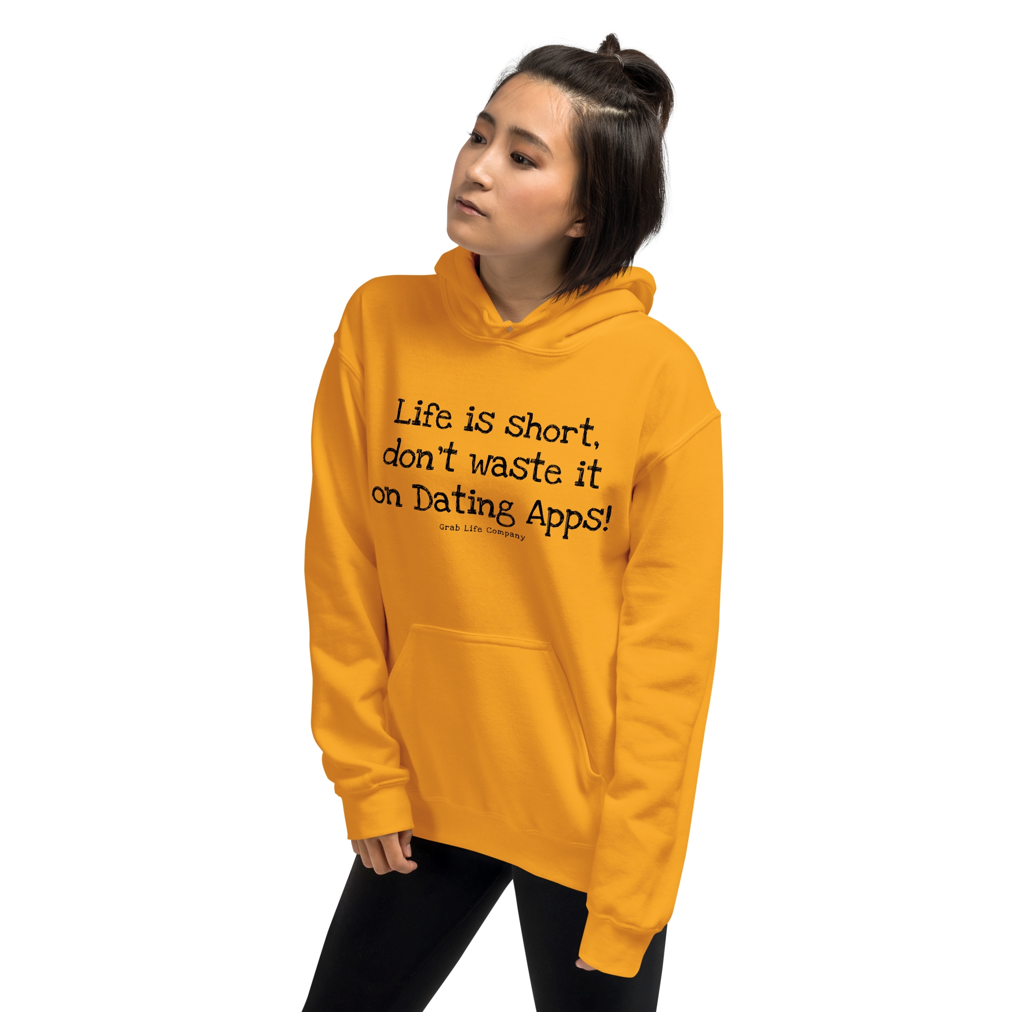 Grab Life Company unisex sweatshirt with Life is Short Don't Waste it on Dating Apps printed in black on Gold yellow hoodie. Image shows woman wearing the sweatshirt.