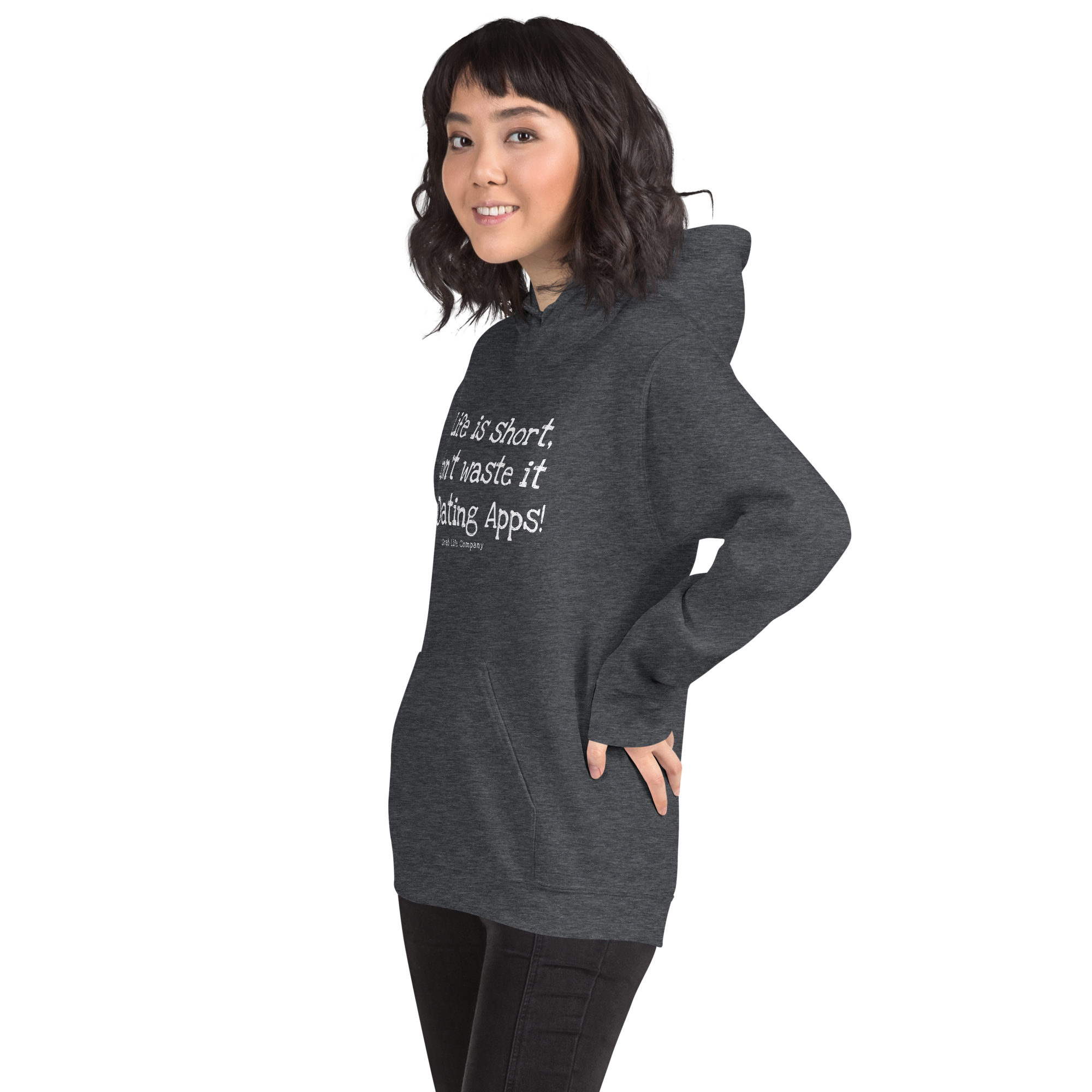 Grab Life Company unisex sweatshirt with Life is Short Don't Waste it on Dating Apps printed in white on dark heather grey hoodie. Image shows woman wearing the sweatshirt.