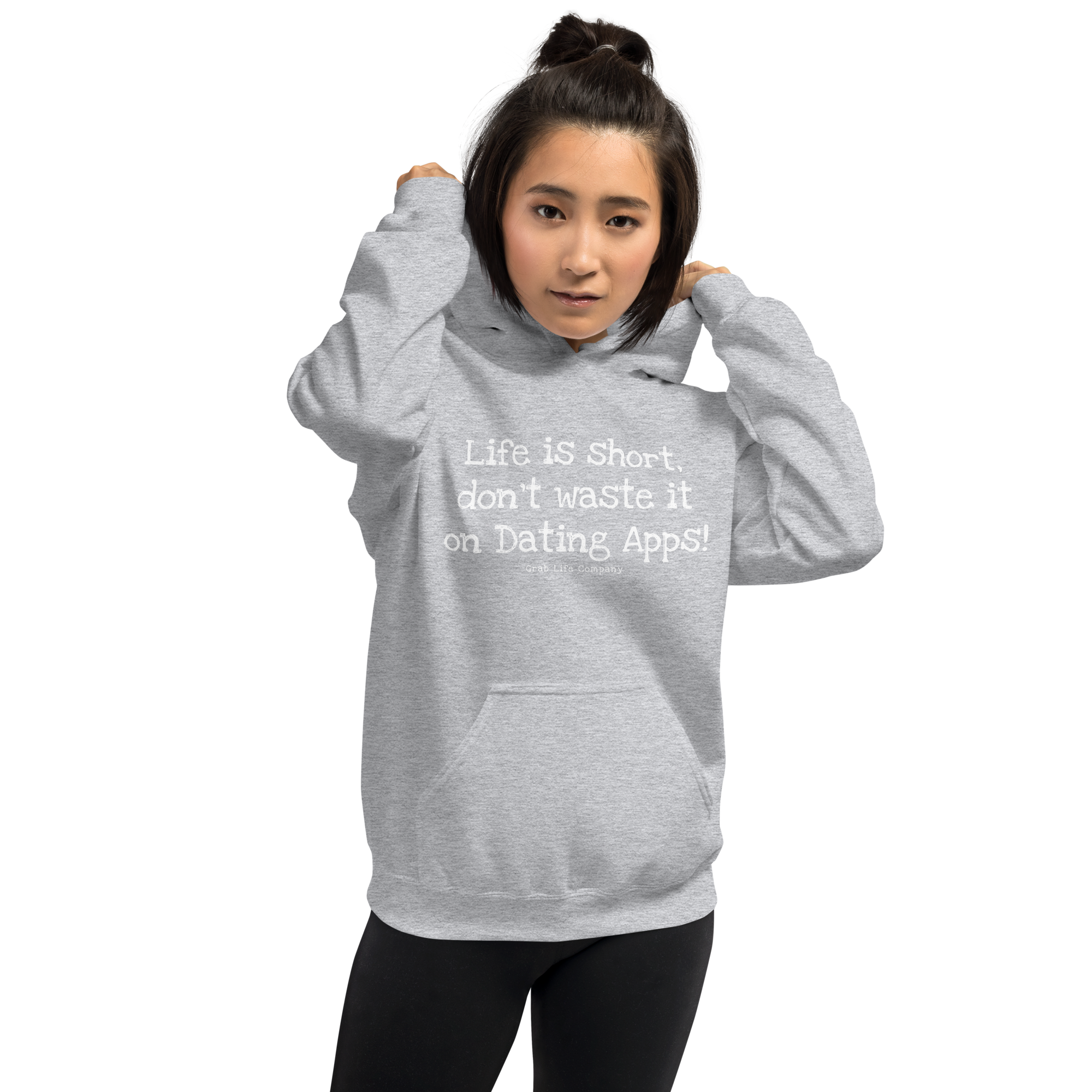 Grab Life Company unisex sweatshirt with Life is Short Don't Waste it on Dating Apps printed in white on sport grey hoodie. Image shows woman wearing the sweatshirt.