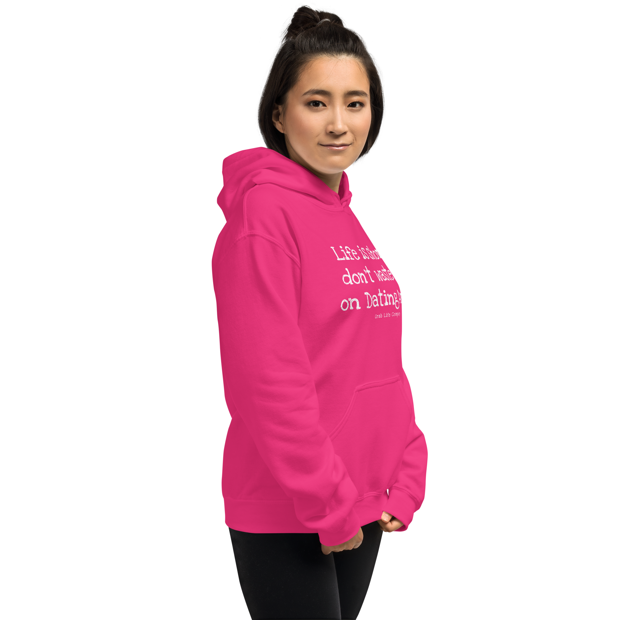 Grab Life Company unisex sweatshirt with Life is Short Don't Waste it on Dating Apps printed in white on heliconia pink hoodie. Image shows woman wearing the sweatshirt.