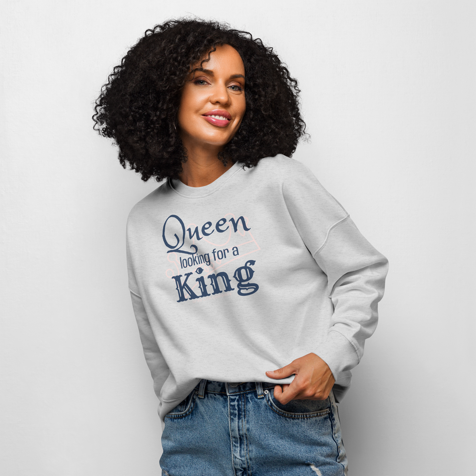 Grab Life Company women's crew neck sweatshirt with Queen Looking for a King printed in navy blue on a heather grey sweatshirt. Image shows a woman wearing the shirt.