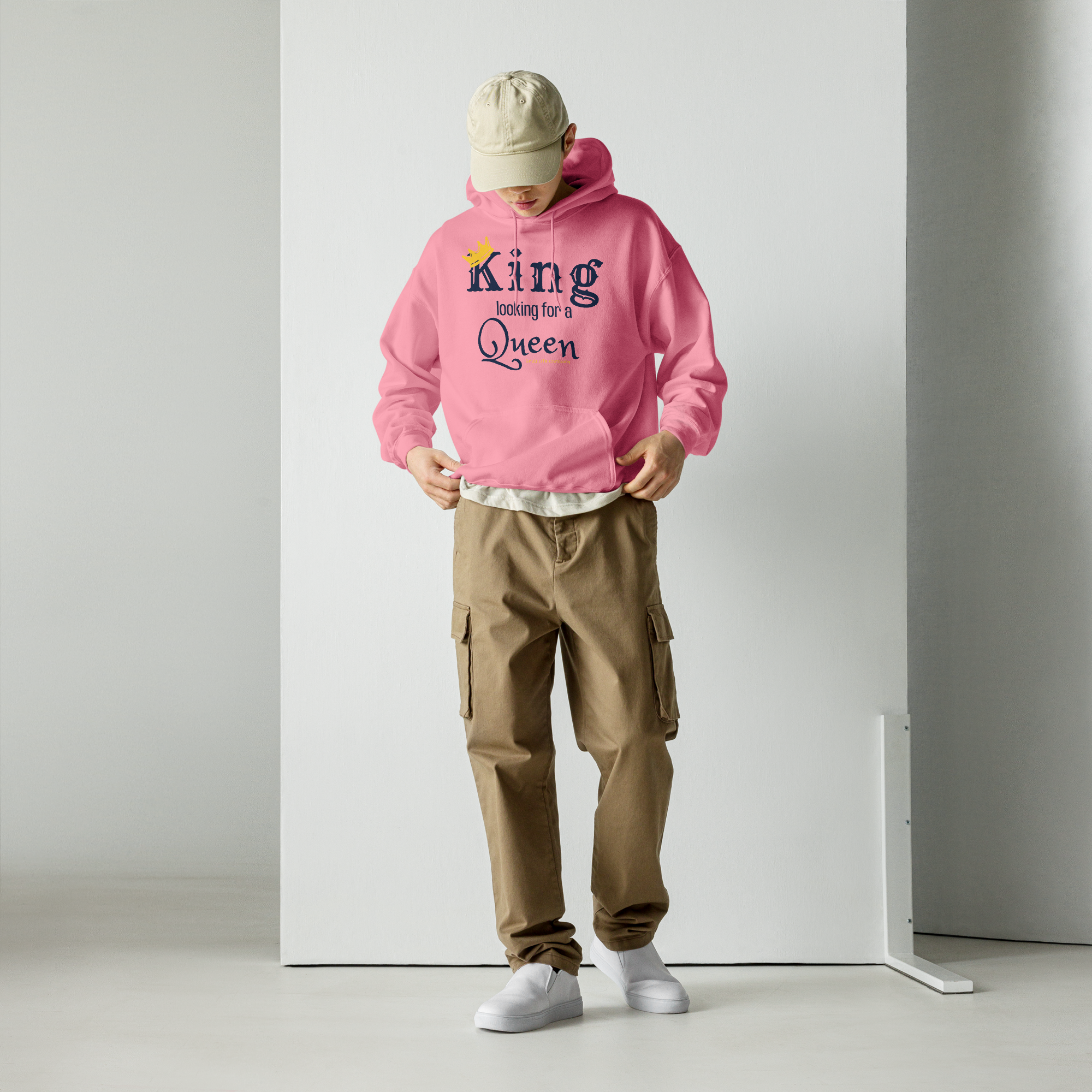Grab Life Company unisex hoodie with King Looking for a Queen printed in navy blue on an Azalea pink sweatshirt. Image shows a man wearing the shirt.