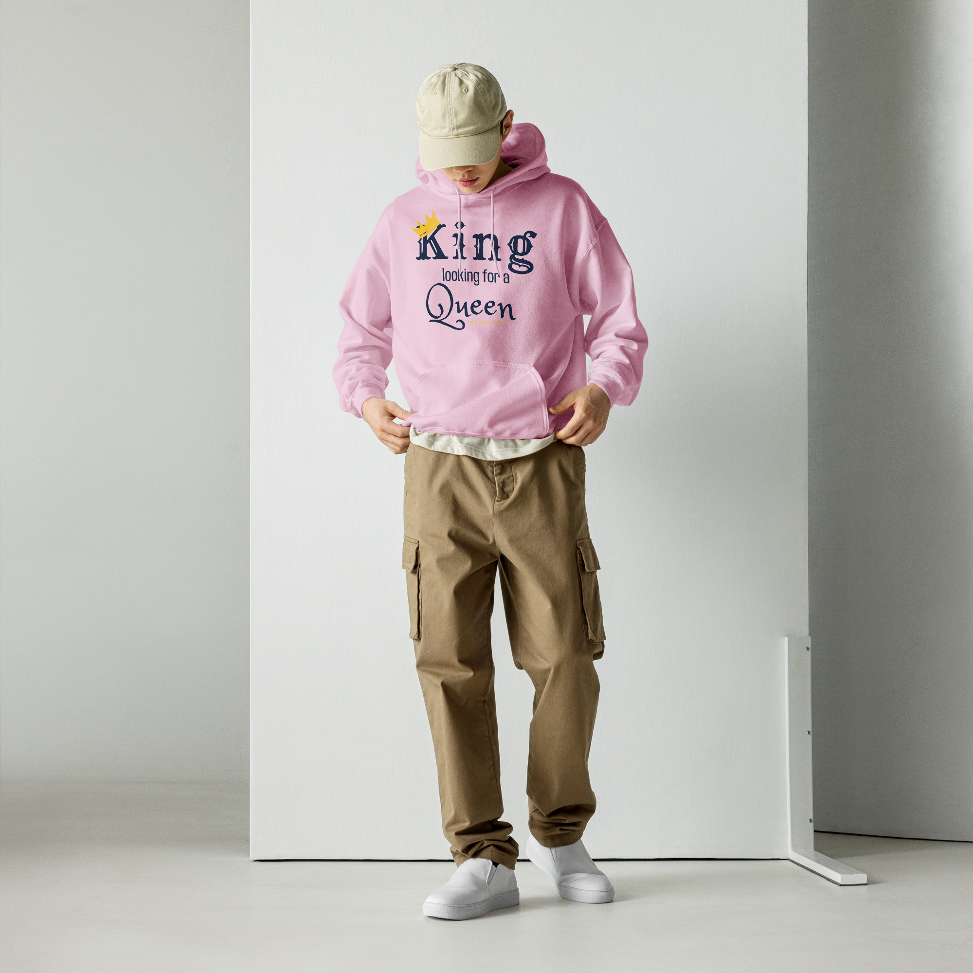 Grab Life Company unisex hoodie with King Looking for a Queen printed in navy blue on a light pink sweatshirt. Image shows a man wearing the shirt.
