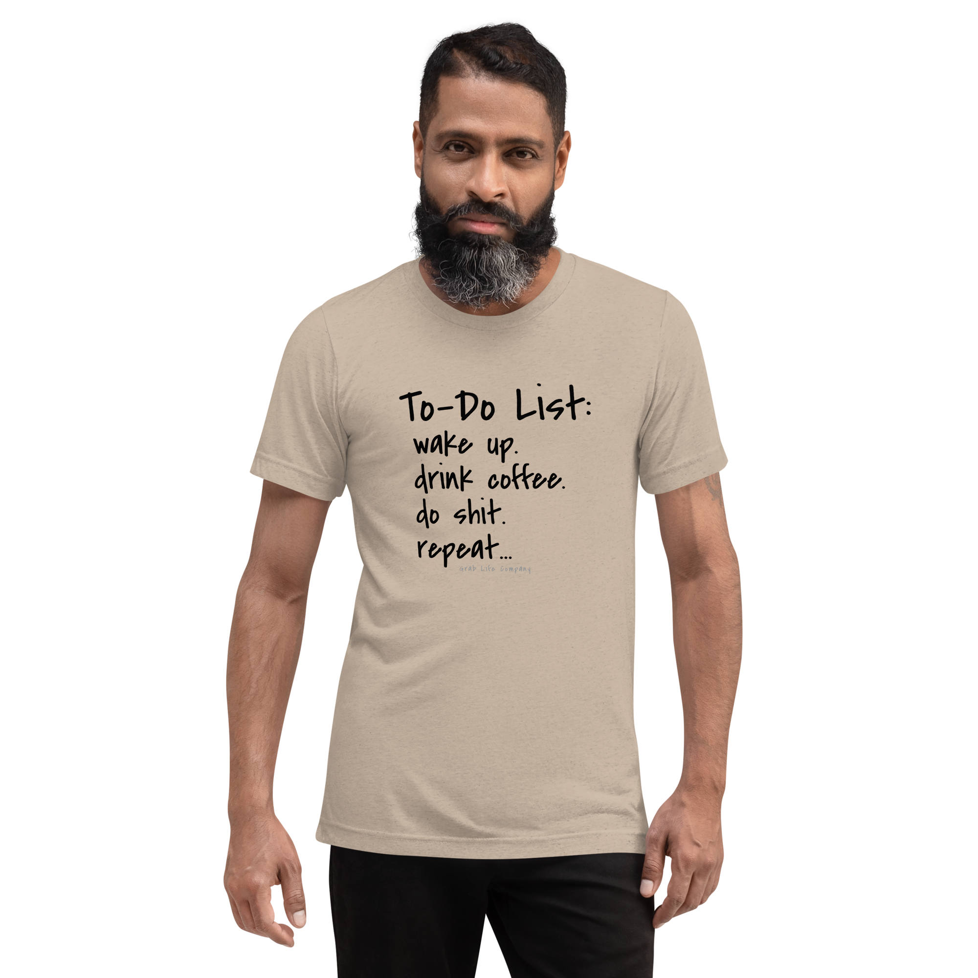 Grab Life Company unisex t-shirt with To-Do List: wake up. drink coffee. do shit. repeat. written on the front in black on a tan triblend tee. Image shows a man wearing the shirt.