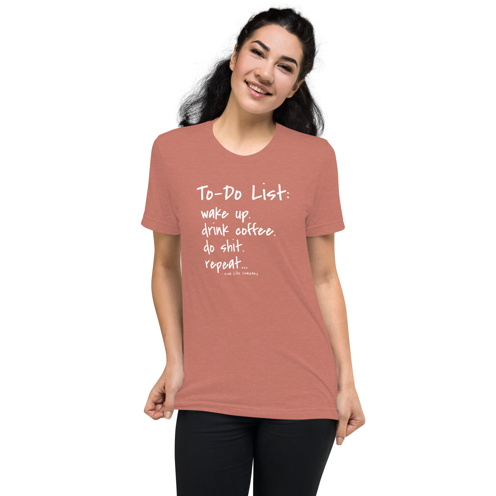 Grab Life Company unisex t-shirt with To-Do List: wake up. drink coffee. do shit. repeat. written on the front in white on a mauve triblend tee. Image shows a woman wearing the shirt.