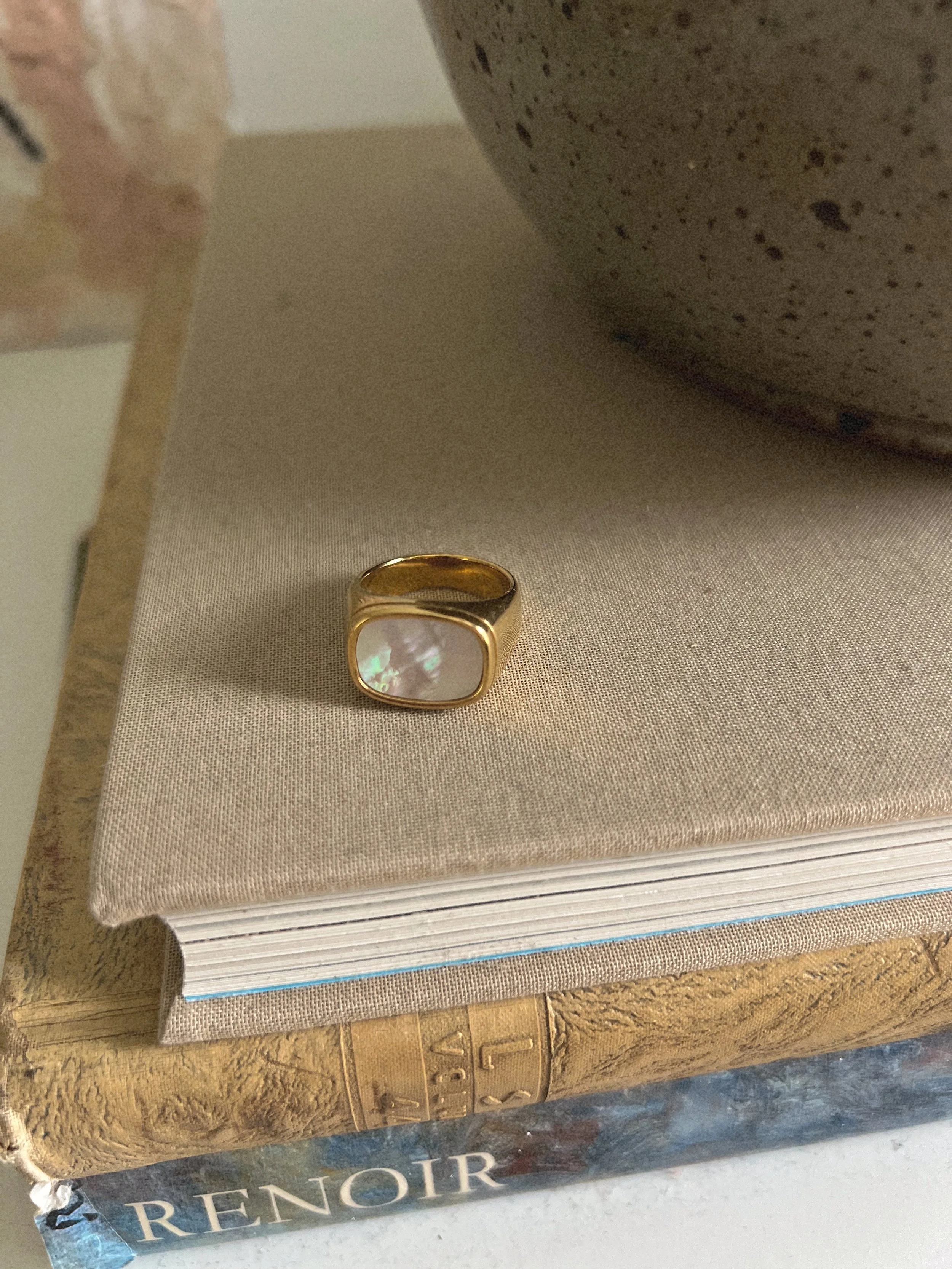 Gold statement ring with an oval stone detail.