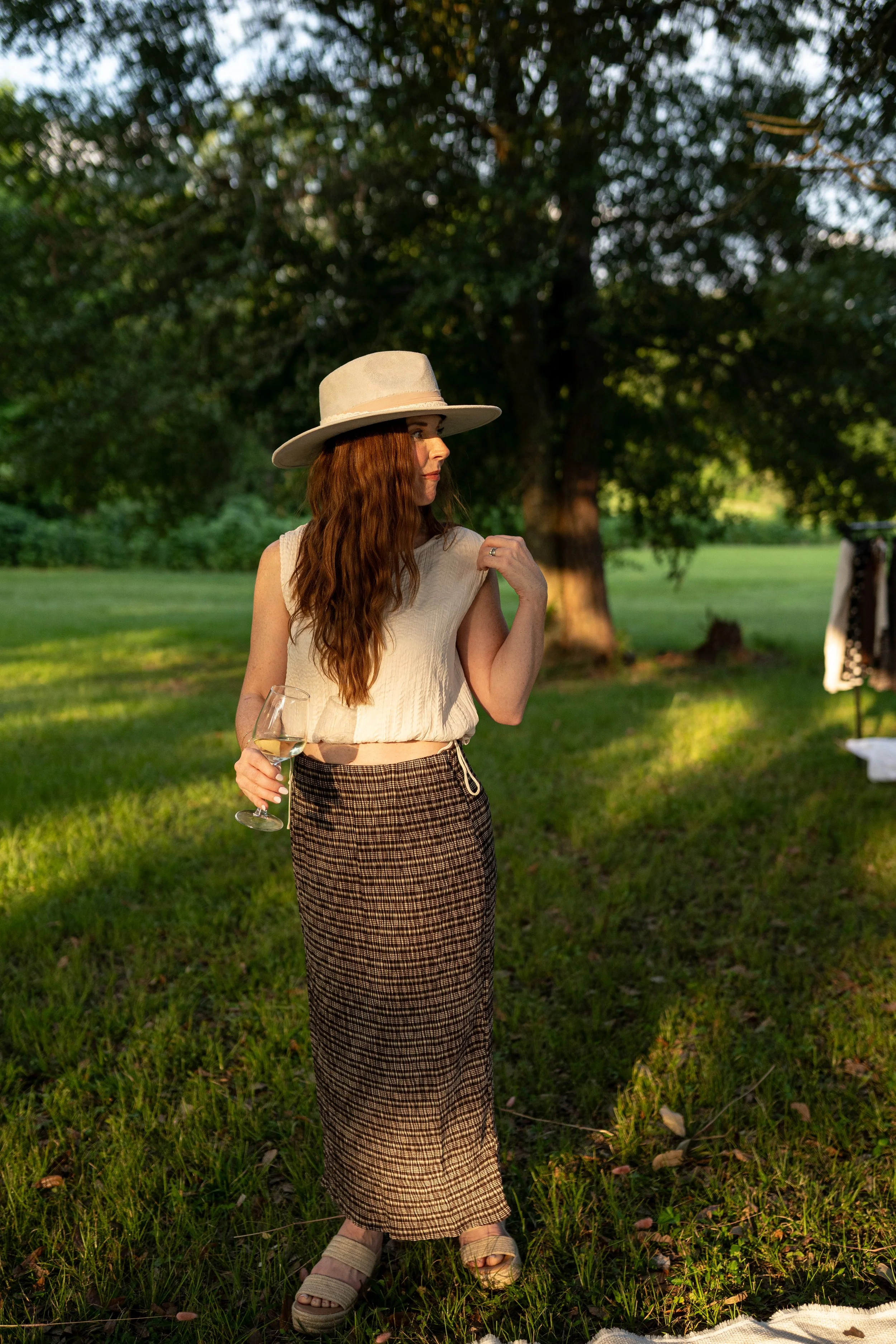 Sleeveless cream top with adjustable waist tie detail.