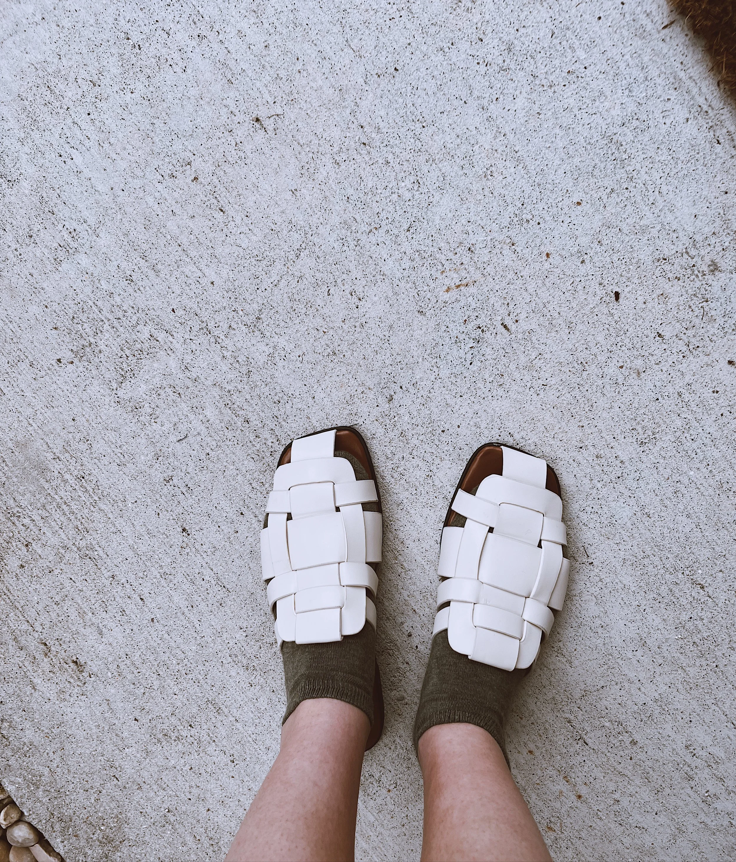 Cream woven flat mules with an open-toe design.