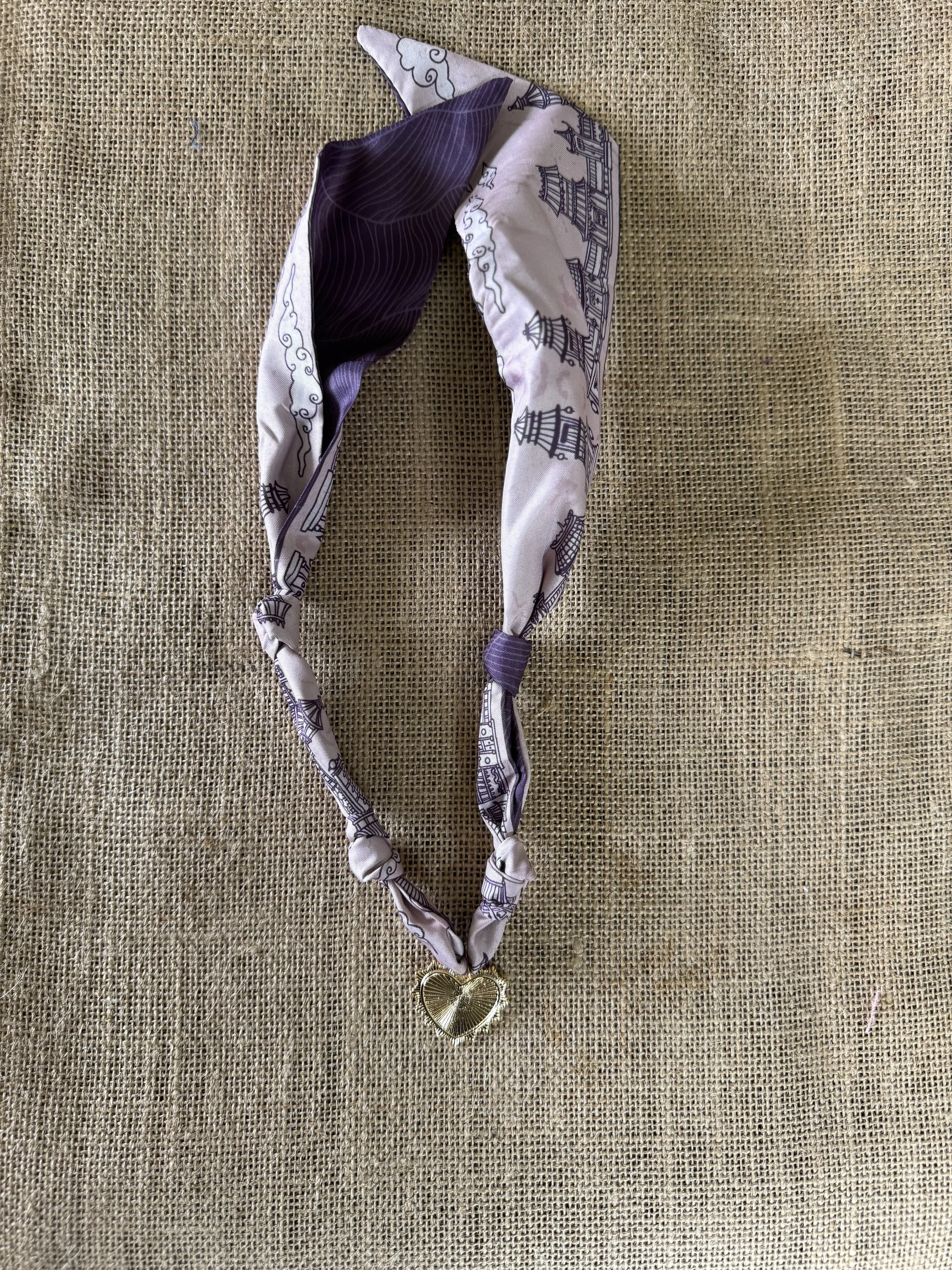 Blue statement necklace with fabric and bead details.