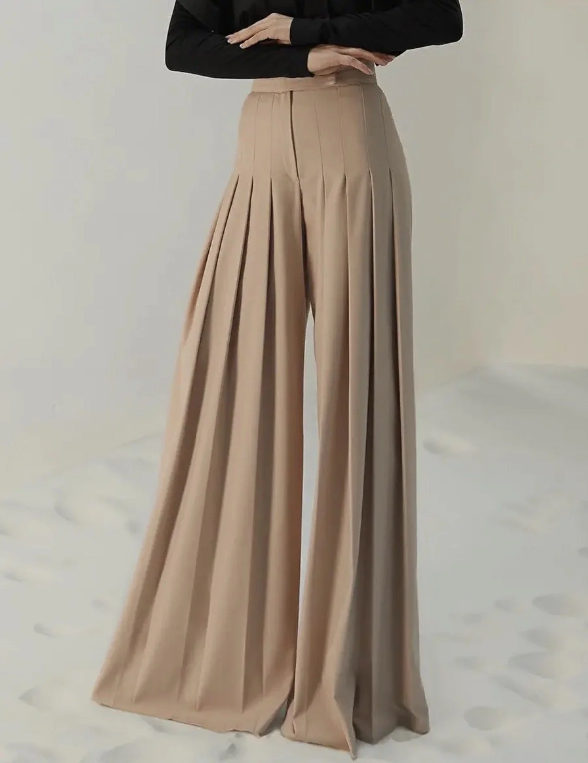 High-waisted beige wide-leg trousers with pleated detail.