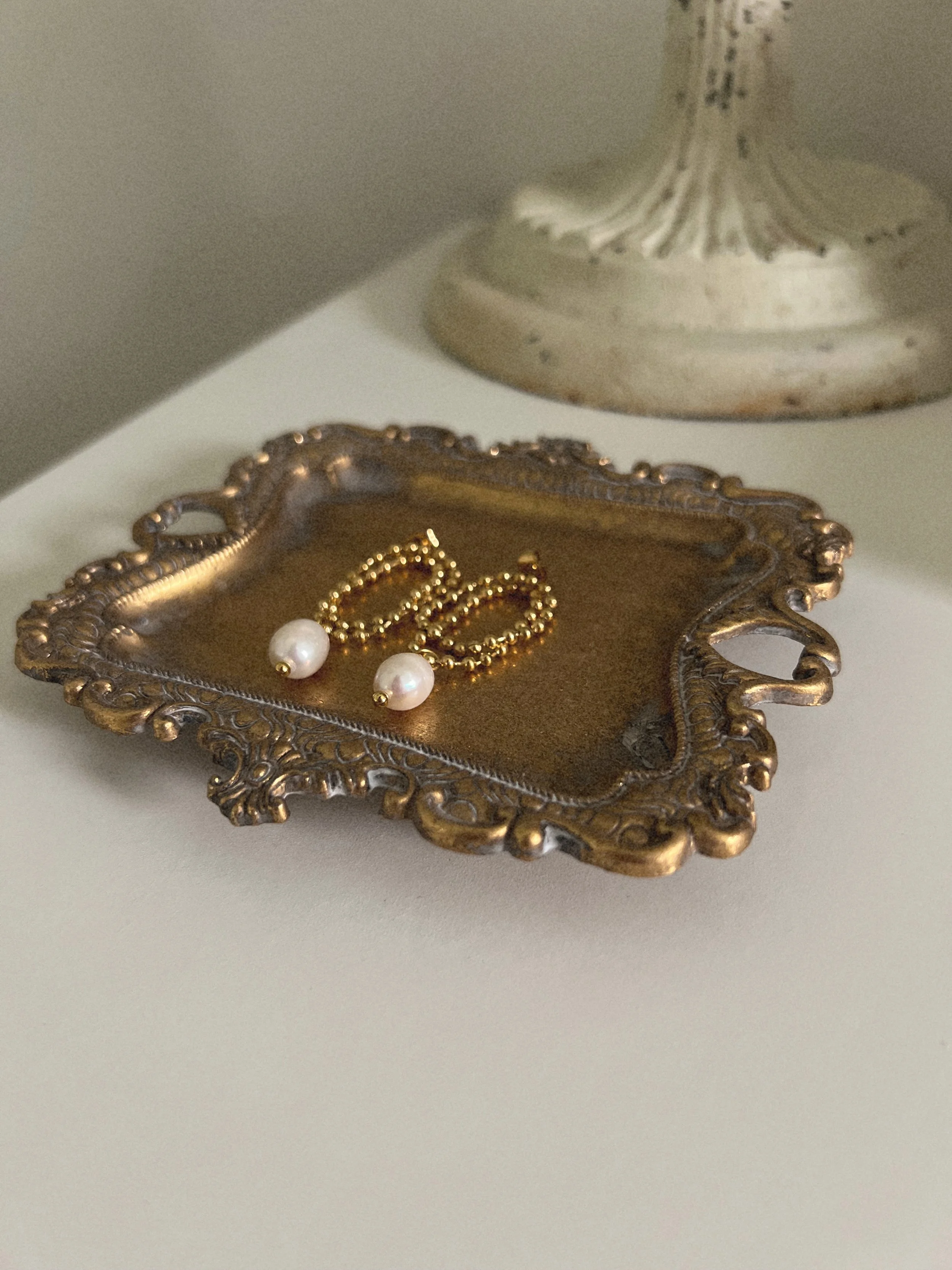 Gold beaded earrings with pearl drop detail.