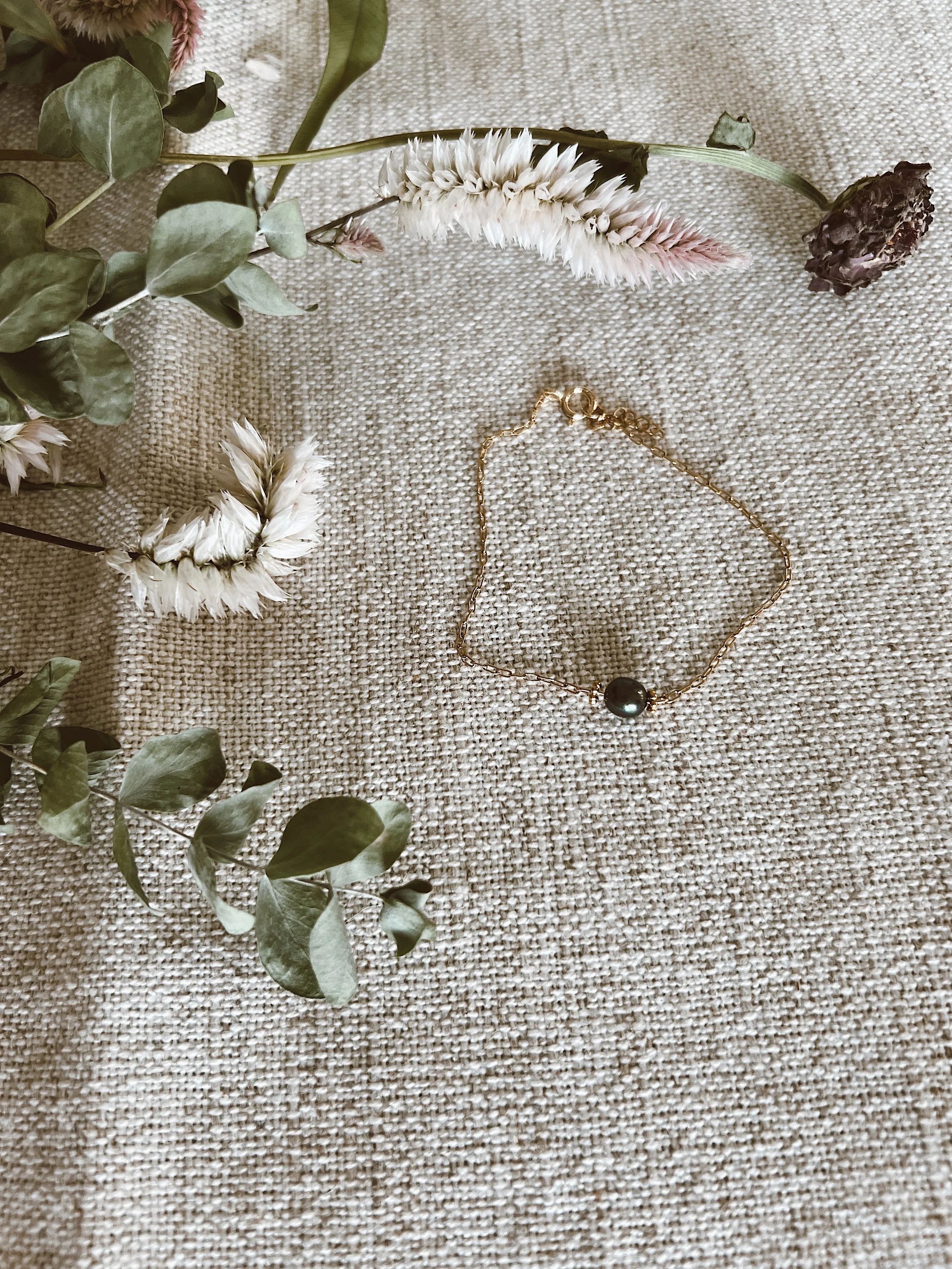 Gold bracelet with authentic black pearl detail.