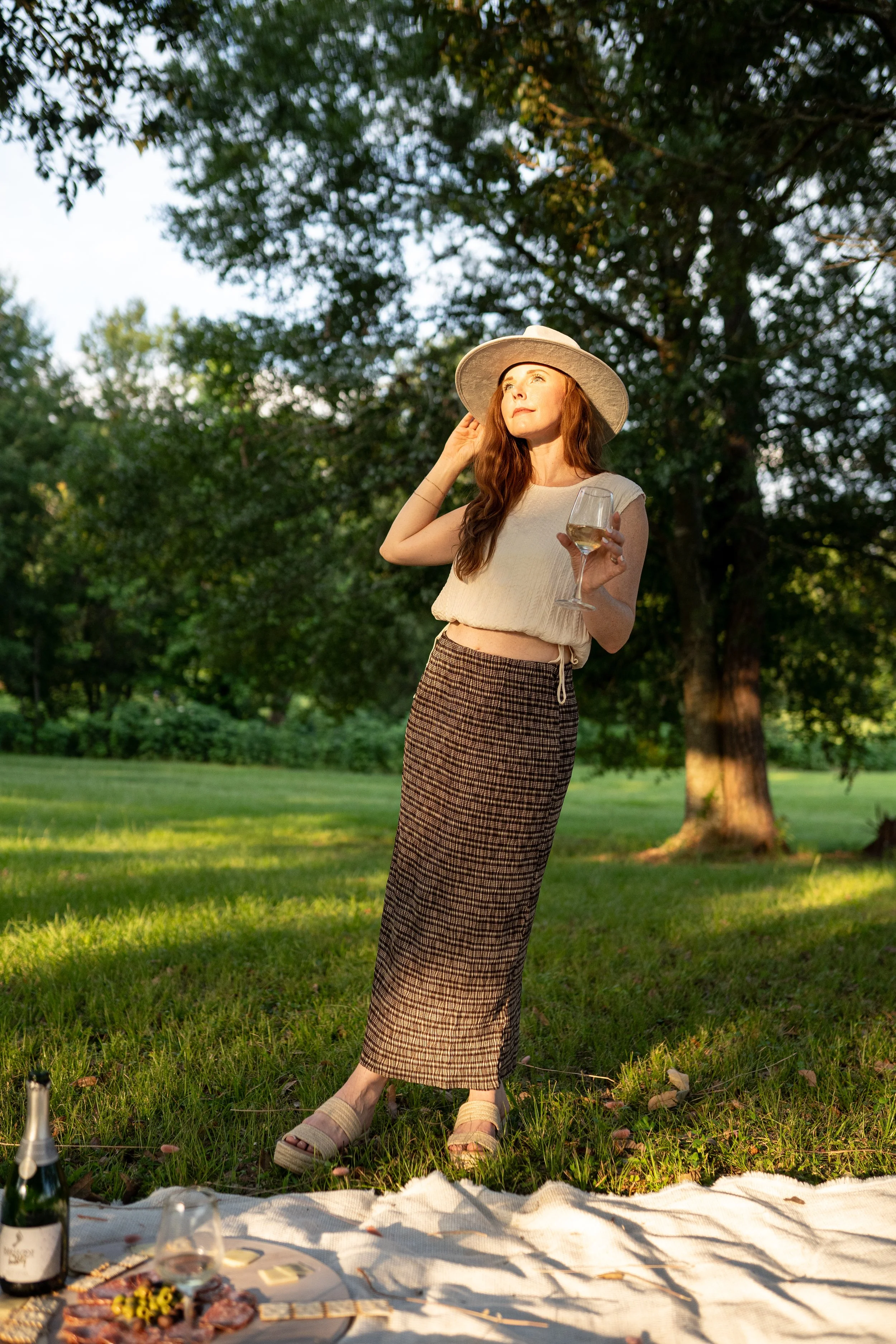 Sleeveless cream top with adjustable waist tie detail.