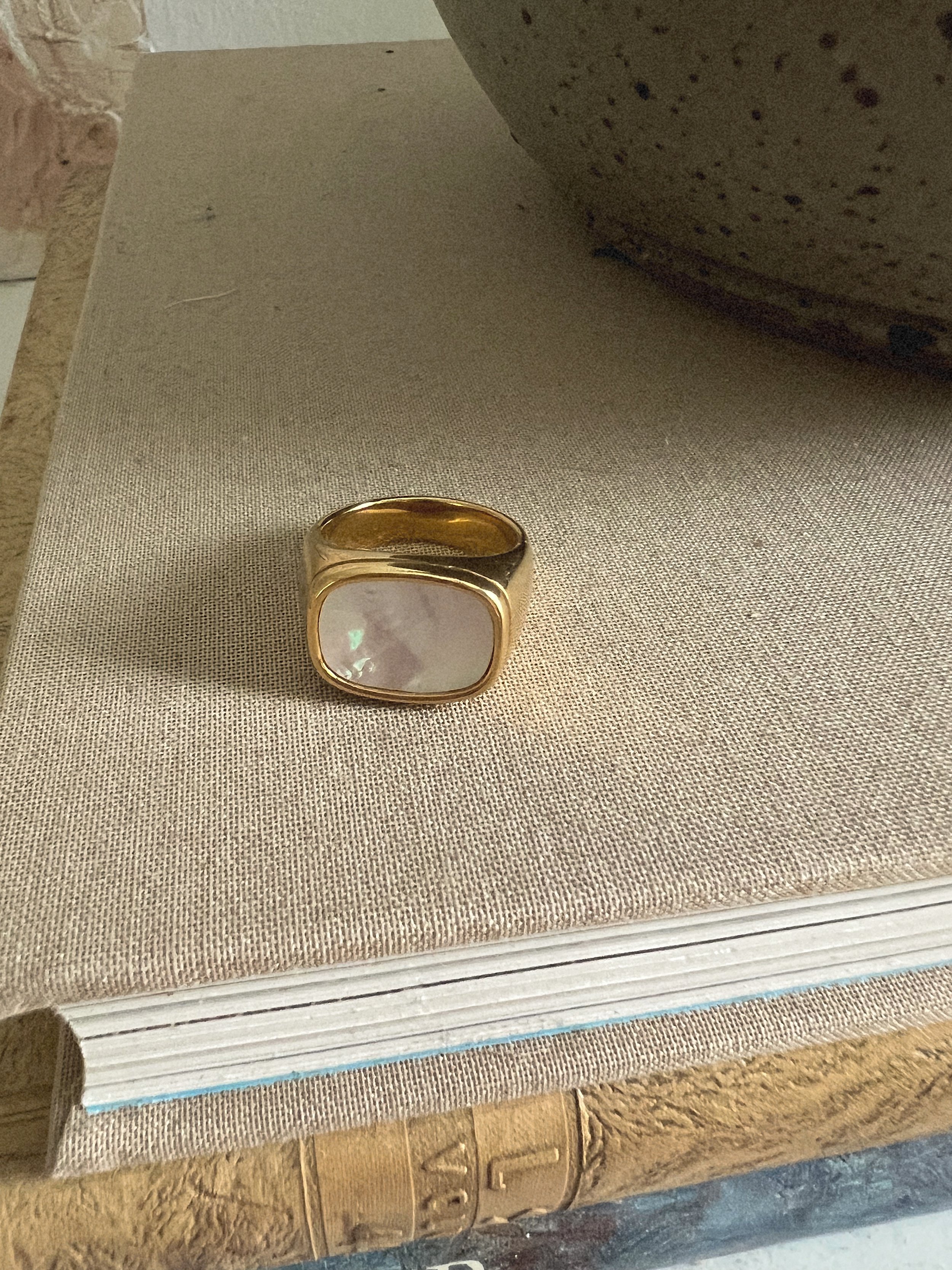 Gold statement ring with an oval stone detail.