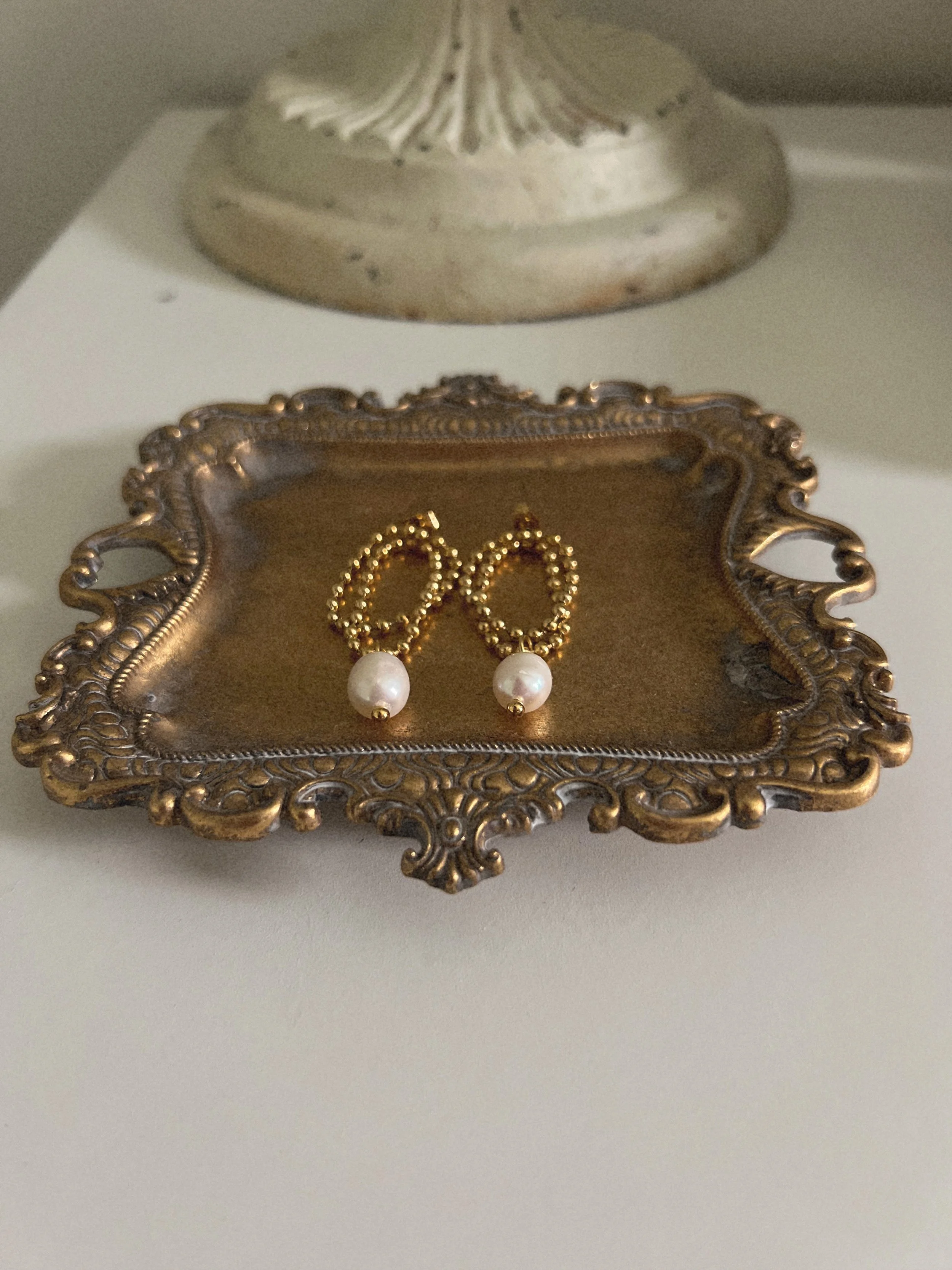 Gold beaded earrings with pearl drop detail.