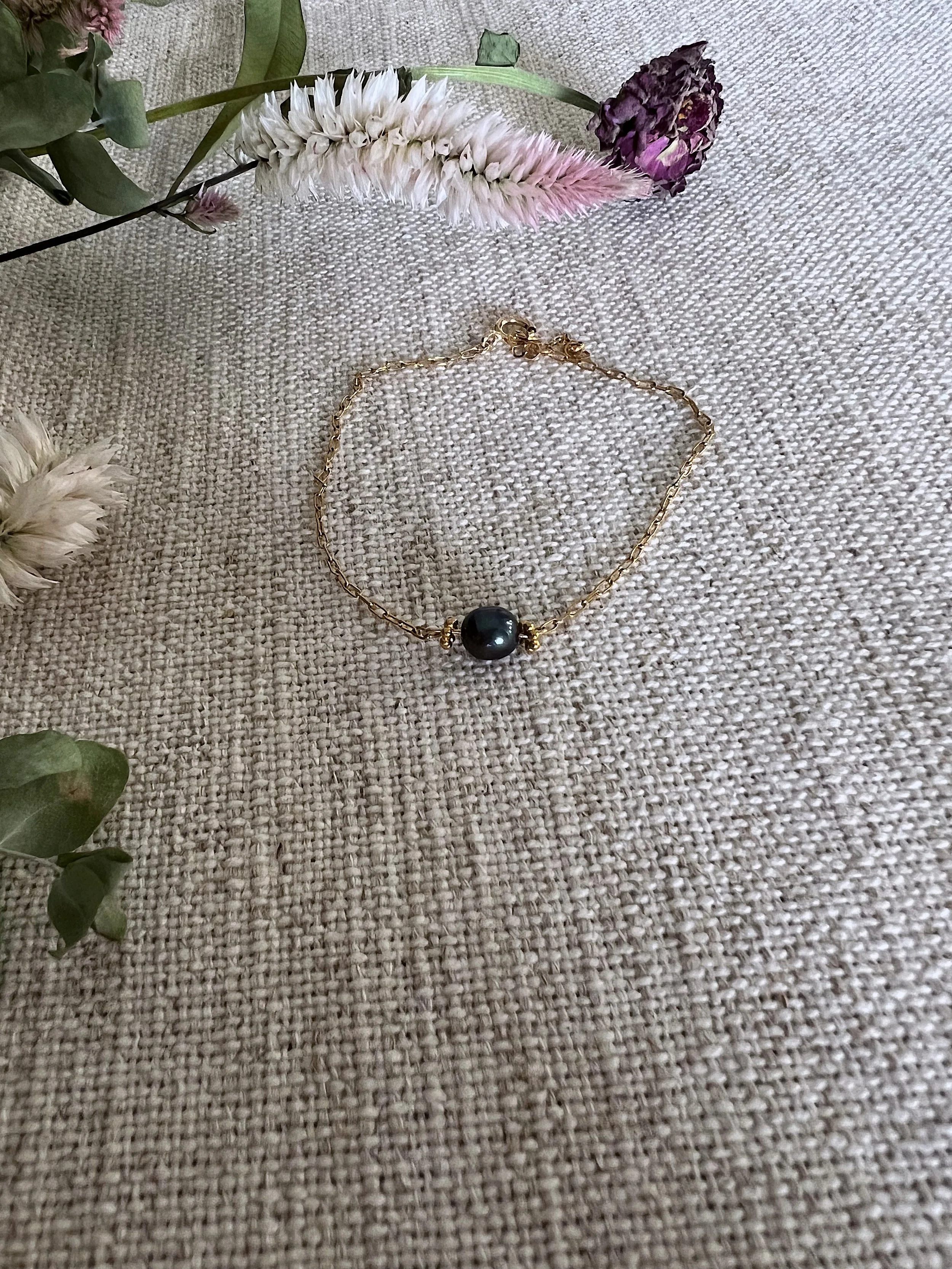 Gold bracelet with authentic black pearl detail.