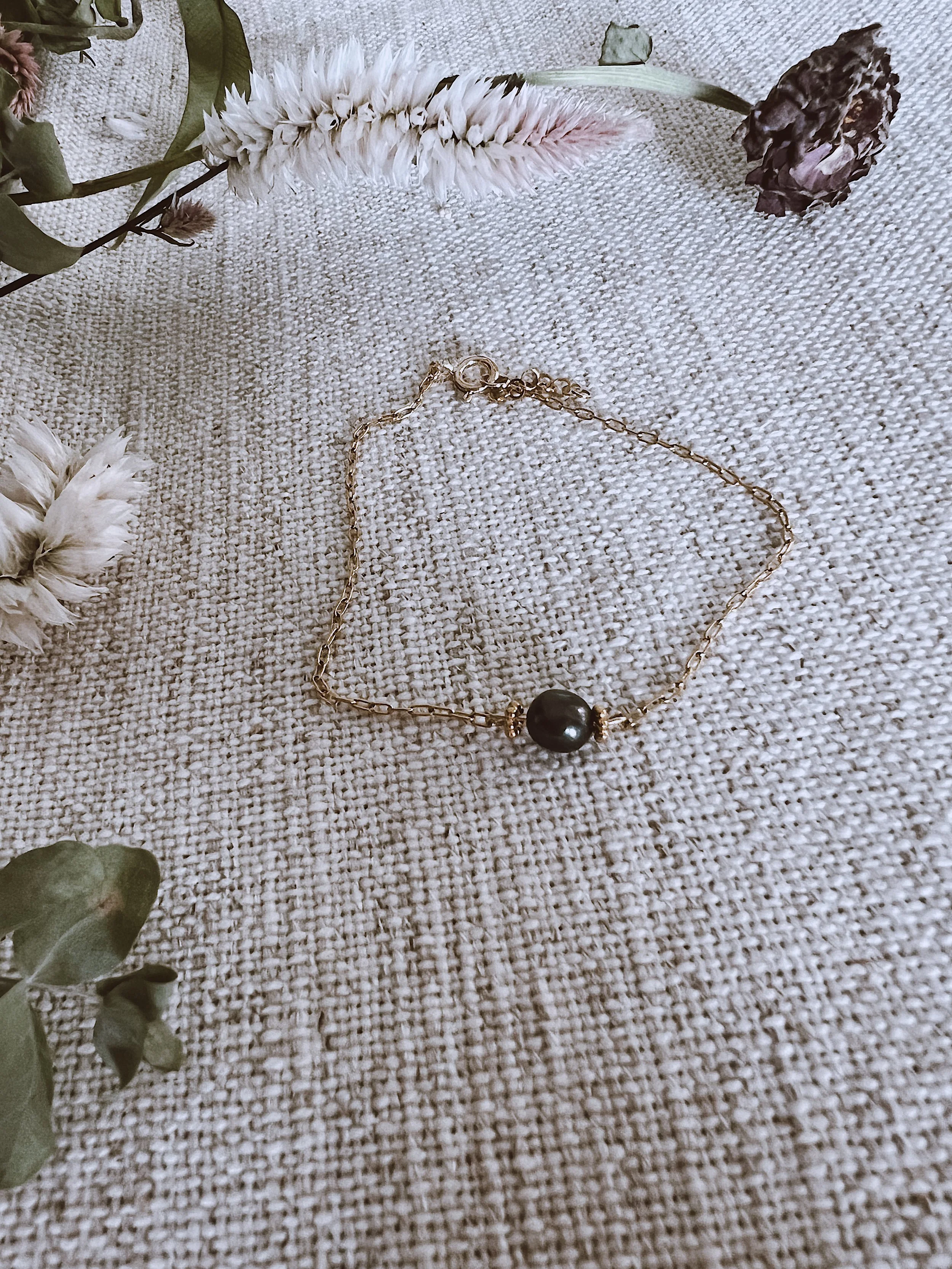Gold bracelet with authentic black pearl detail.