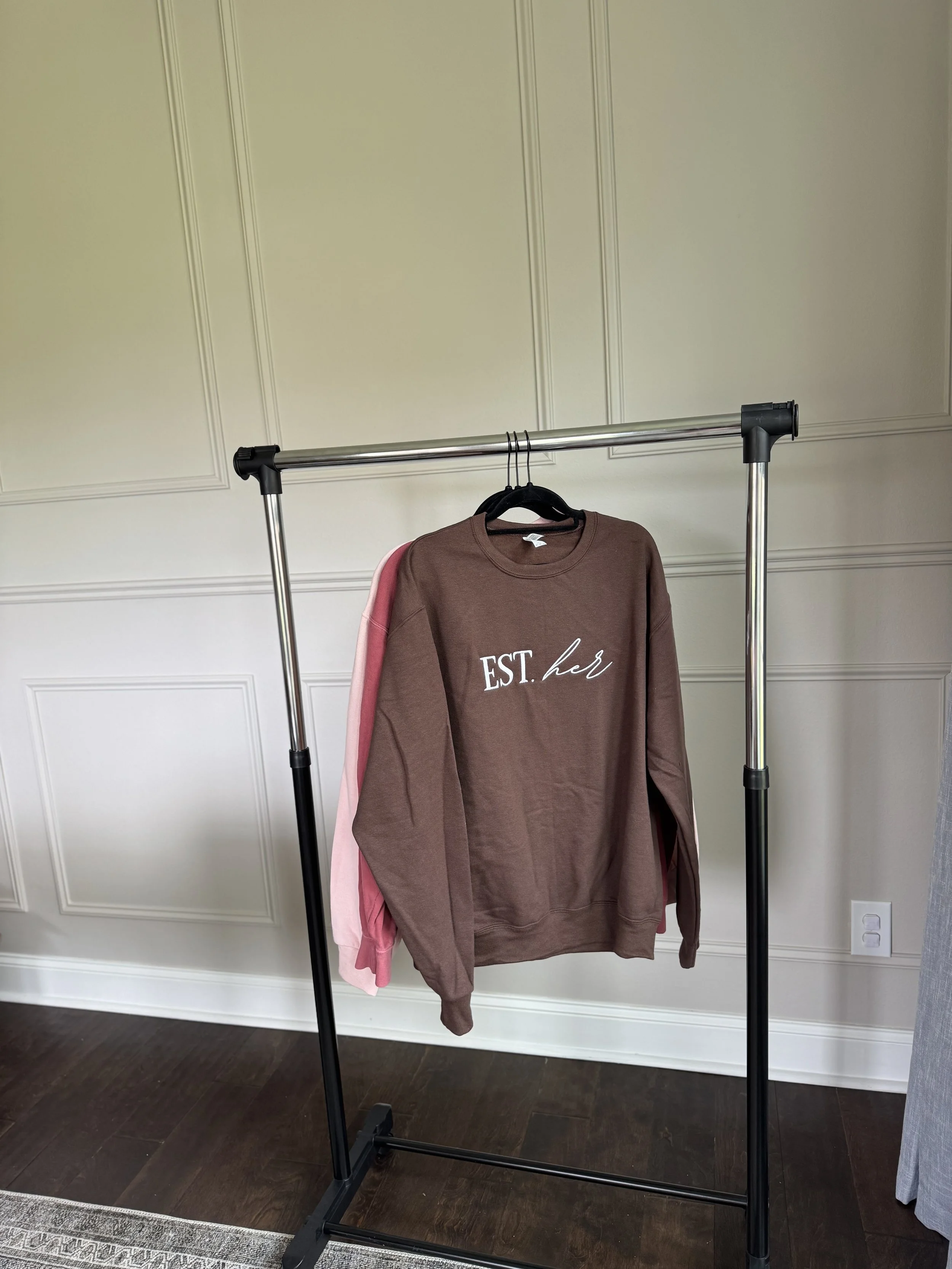 Dusty rose sweatshirt with Esther logo graphic.