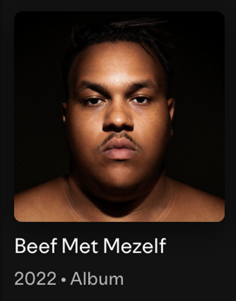 Close-up portrait of a young man with a serious expression, dark background, and minimal clothing, with text showing album title 'Beef Met Mezlef' and year 2022.