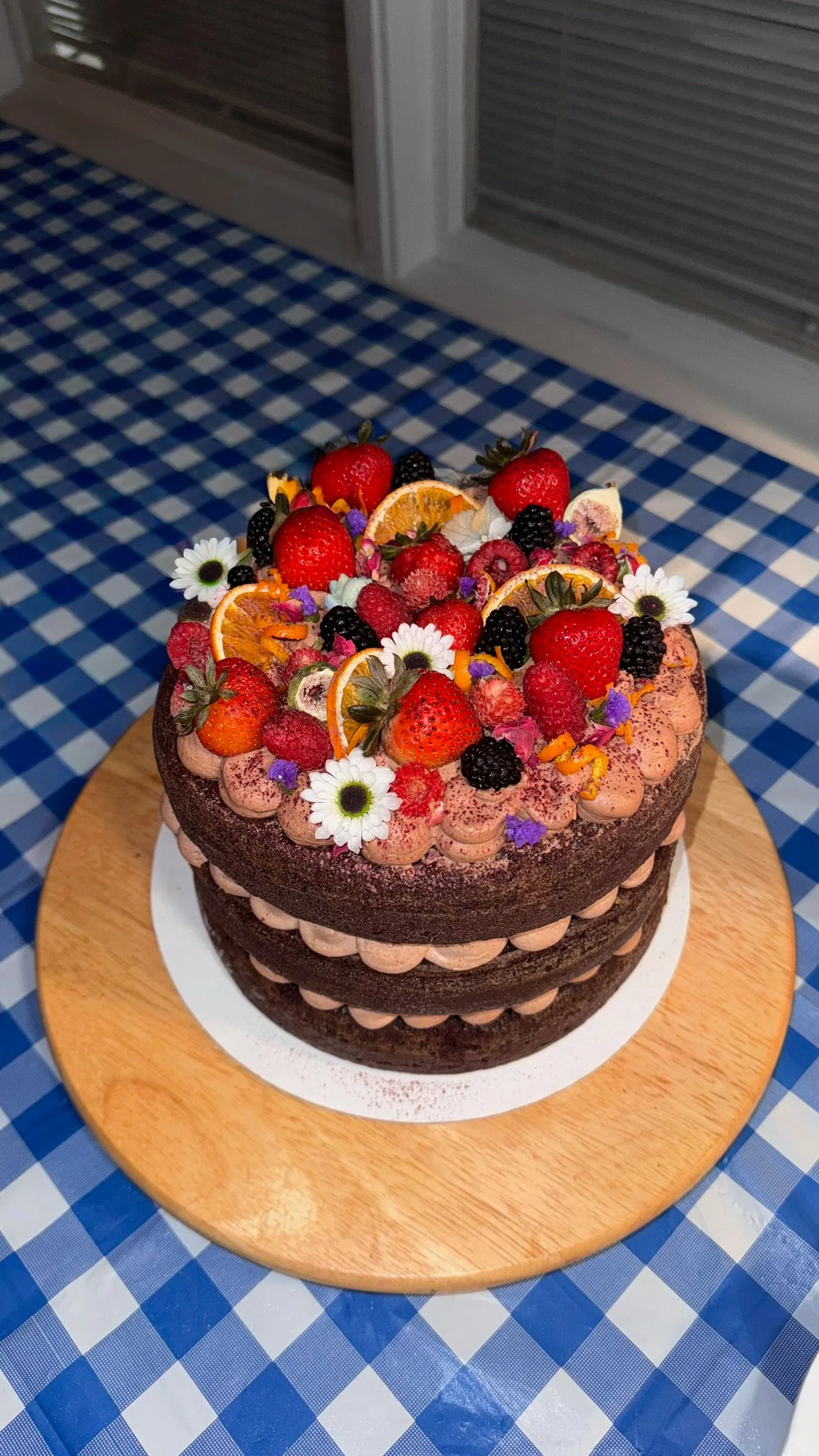 Premium Custom Birthday Cake, 9 inch round
Three-layer Ghirardelli dark chocolate-orange cake, dark chocolate-orange mousse, dark chocolate ganache with homemade orange jam. Topped with fresh berries and citrus and assorted edible flowers. 
Serves 18