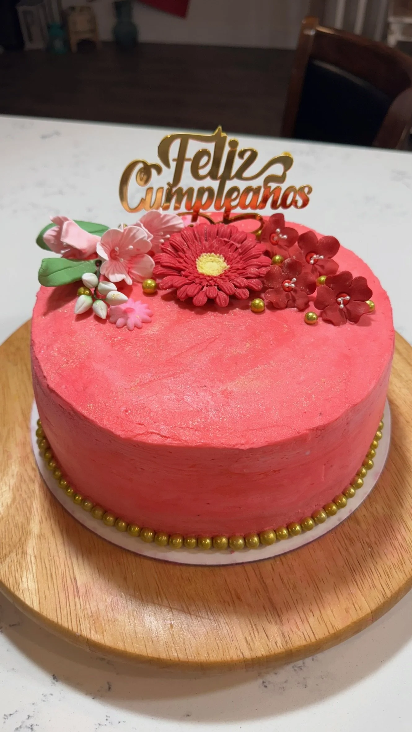 Custom birthday cake, 9.5inch. 
Strawberry cake with strawberry cream cheese filling and fresh strawberry slices and American buttercream icing.
Topped with custom-made edible gum paste flowers.
Serves 20-30.