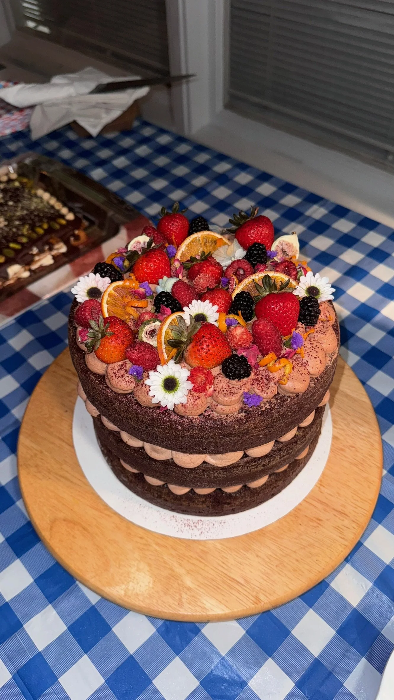 Premium Custom Birthday Cake, 9 inch round
Three-layer Ghirardelli dark chocolate-orange cake, dark chocolate-orange mousse, dark chocolate ganache with homemade orange jam. Topped with fresh berries and citrus and assorted edible flowers. 
Serves 18
