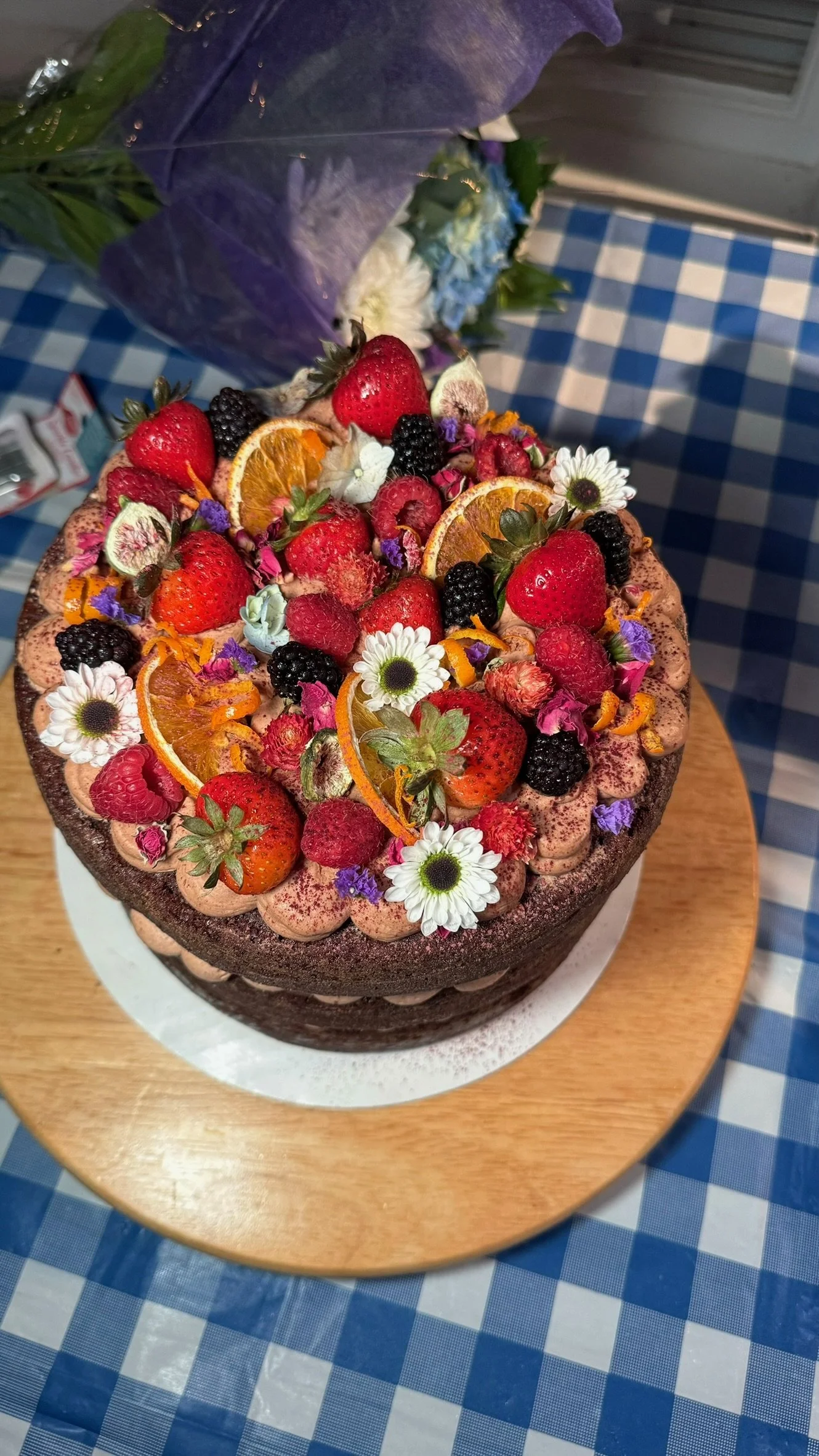Premium Custom Birthday Cake, 9 inch round
Three-layer Ghirardelli dark chocolate-orange cake, dark chocolate-orange mousse, dark chocolate ganache with homemade orange jam. Topped with fresh berries and citrus and assorted edible flowers. 
Serves 18