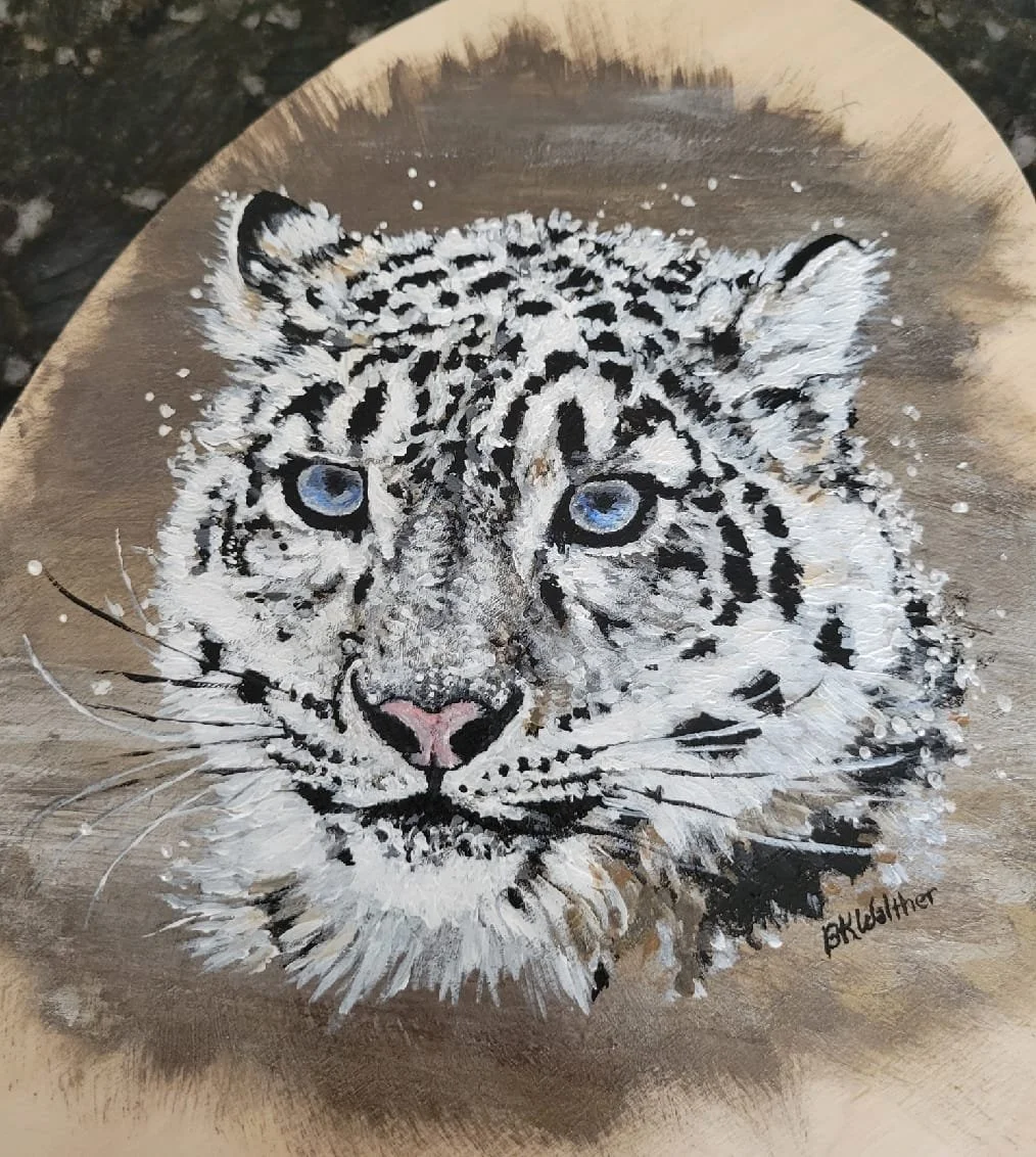 Painting of a white leopard with blue eyes on a circular, brown background.