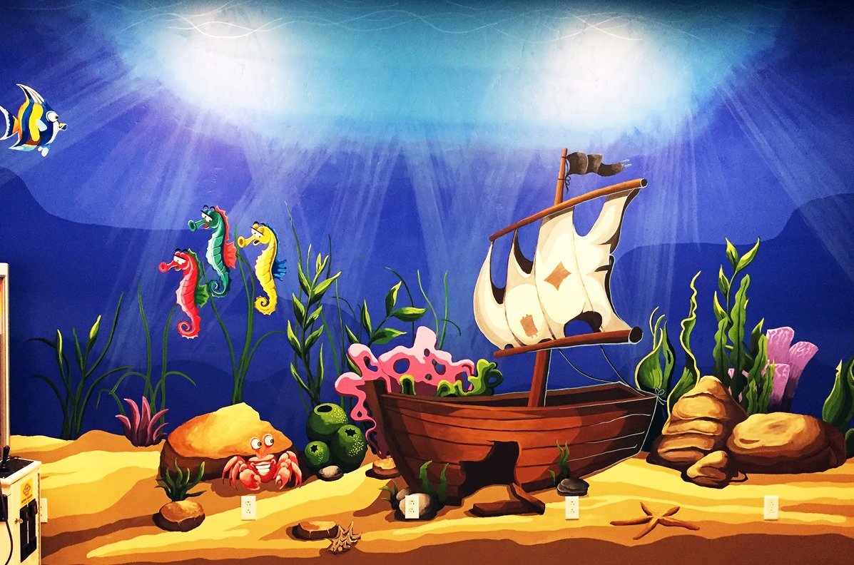 Colorful underwater scene mural with a shipwreck, seahorses, a crab, starfish, rocks, coral, seaweed, and an ocean backdrop with sunlight beams.