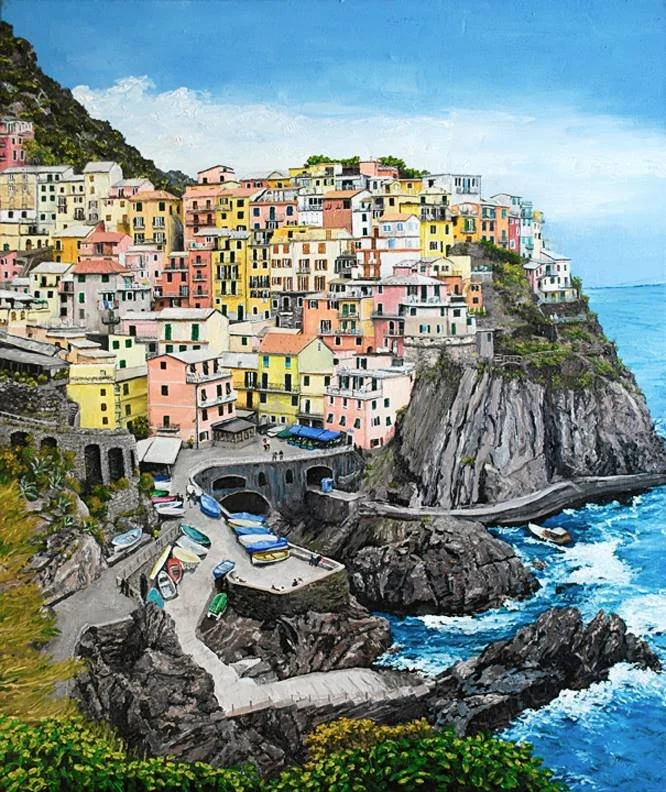 Colorful houses stacked on a cliffside overlooking the ocean in a coastal town.