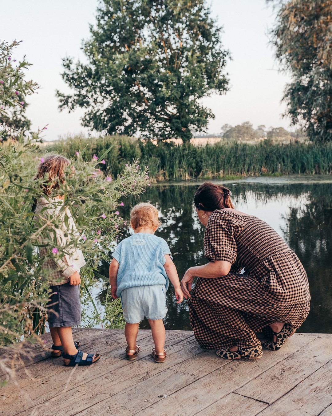Mother and her children looking into a lake during an outdoor family photography session.
