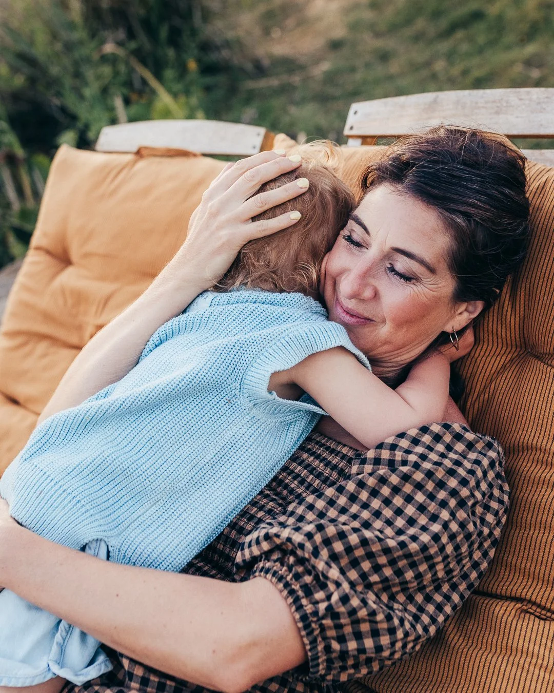 Mother snuggling her child at The Lodge in Essex during golden hour.