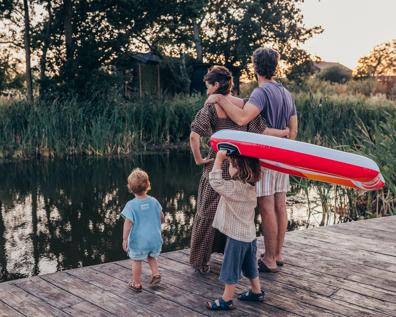 Young family enjoying time together at their home retreat at golden hour in the Essex countryside.