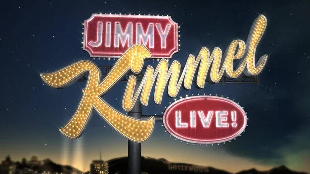 Sign for Jimmy Kimmel Live! show at night with bright lights and cityscape in the background.