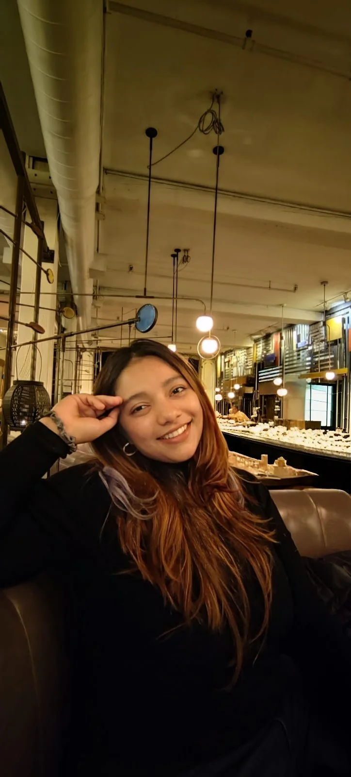 A young woman therapist with long, wavy red hair, smiling who is the founder of soh:m