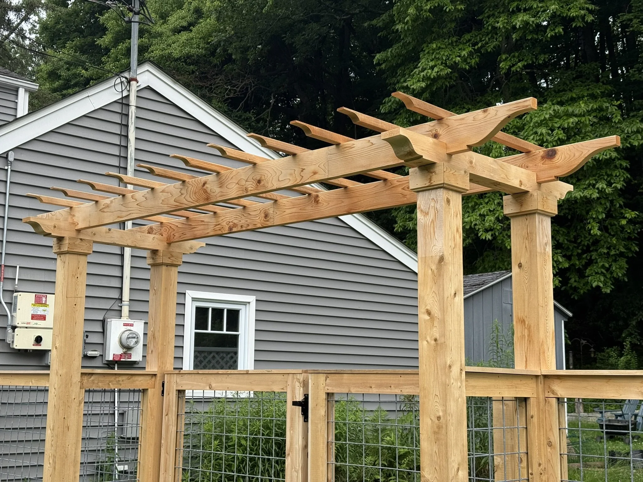 Custom cedar picture frame fence with arbor topper in Bethel, CT.
