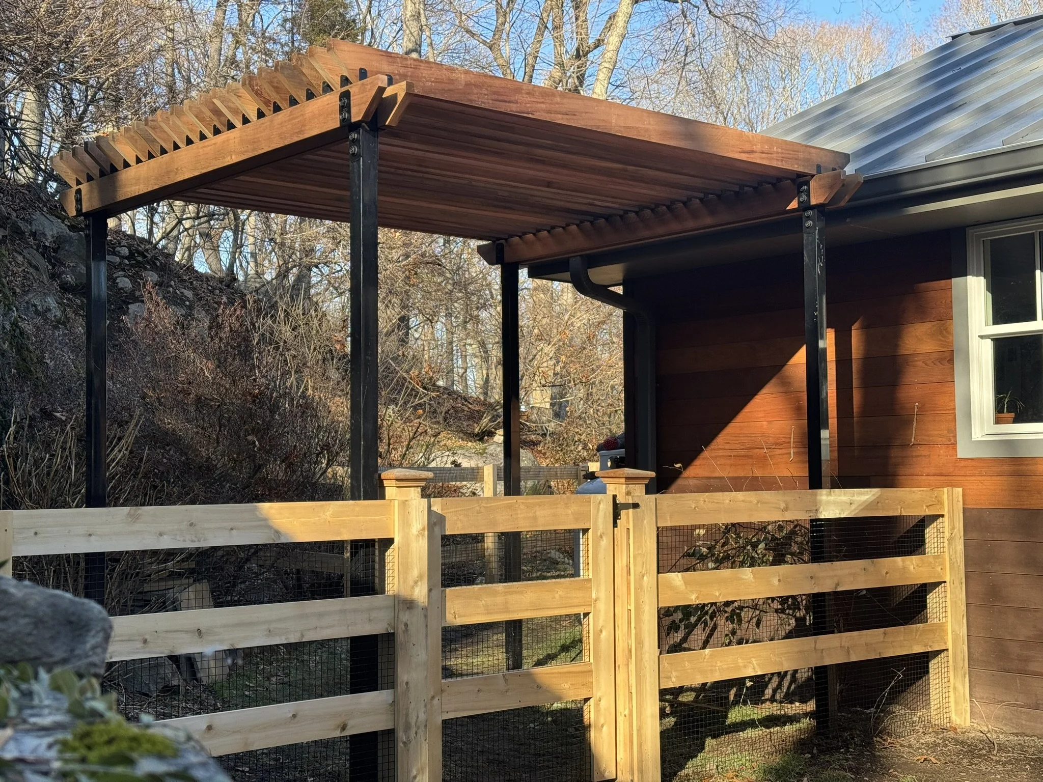 Cedar 3-Board style fence with gate and custom clear red cedar pergola with steel posts in Darien CT