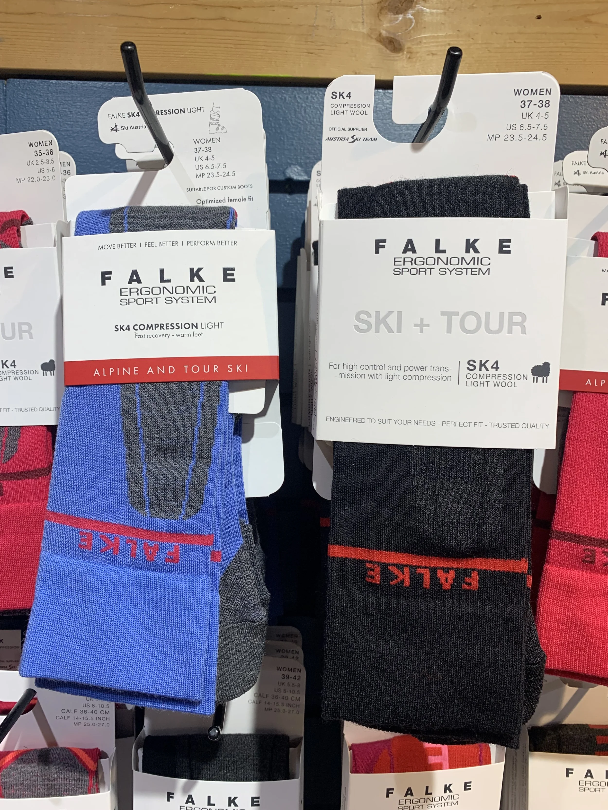 Display of Falkes ski socks in black and blue, with Ski Austria logos, on a store rack.
