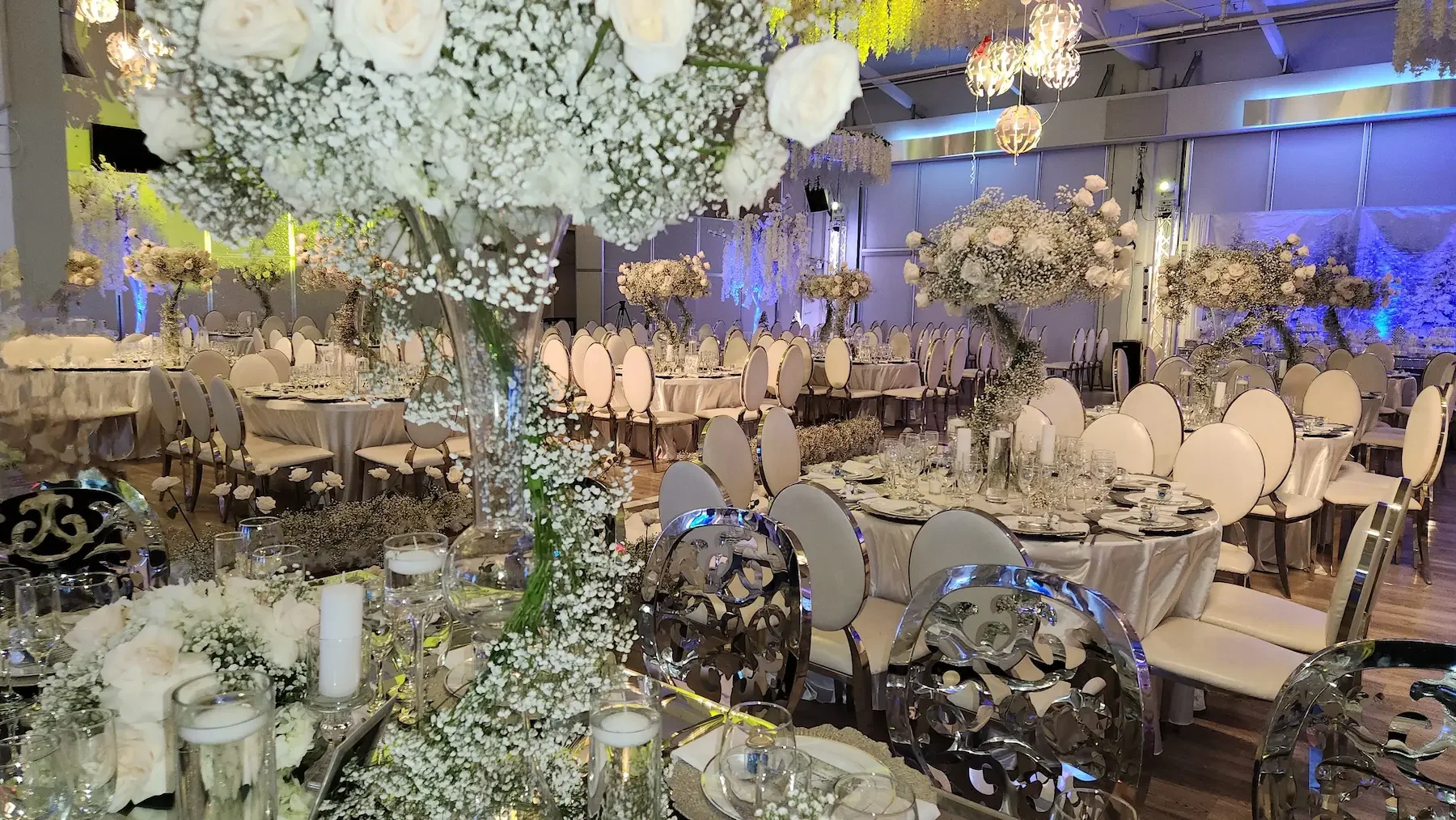 Wedding reception setup at The QD Venue grand ballroom with floral centerpieces and banquet tables.