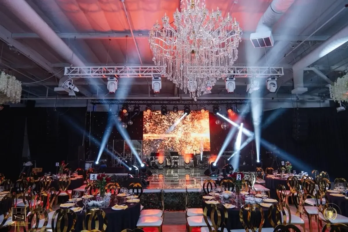 Grand ballroom at The QD Venue in Westminster, California featuring chandelier lighting, concert-style stage, and banquet seating for a wedding reception.
