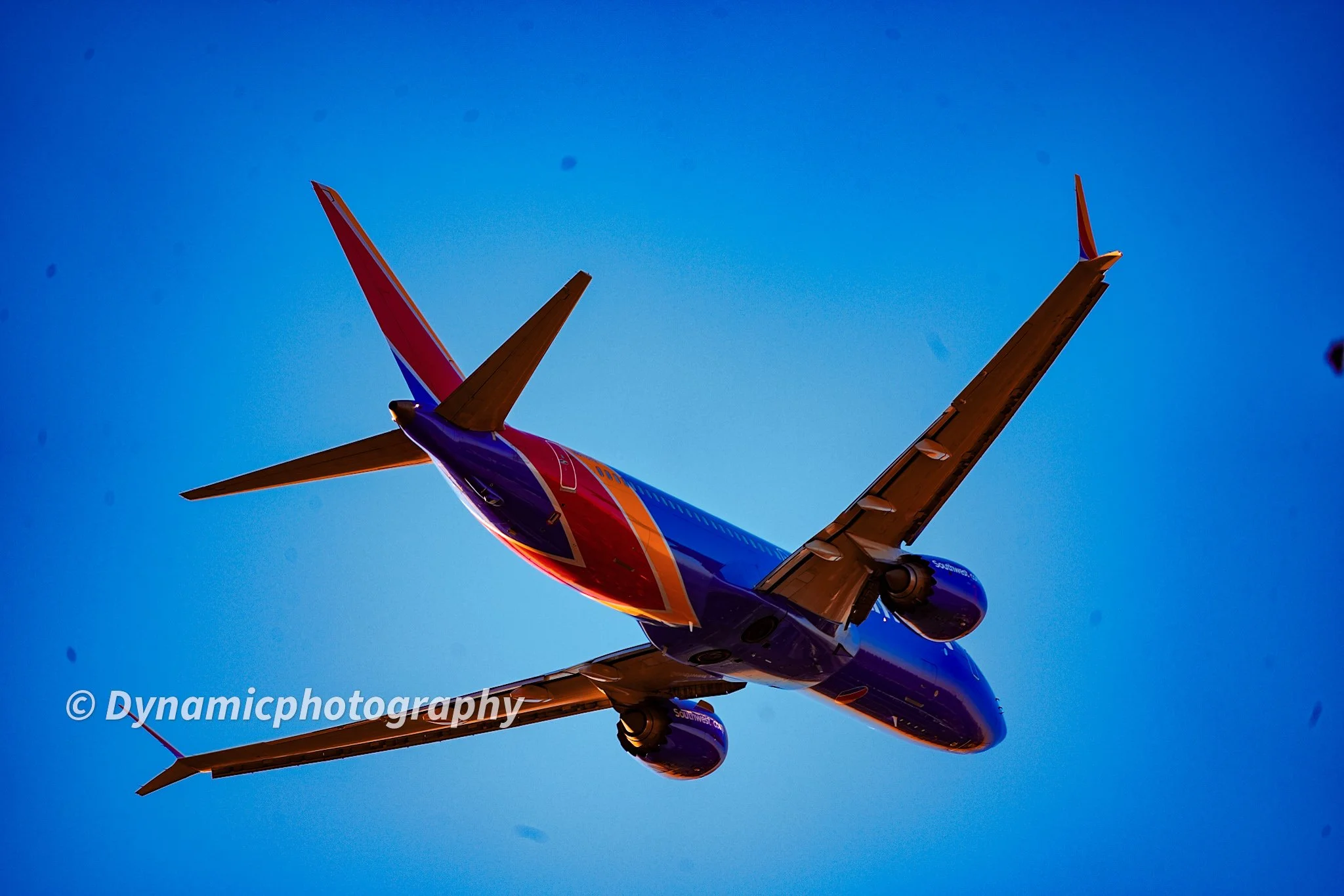 A Southwest Airlines airplane flying in a clear blue sky viewed from below.