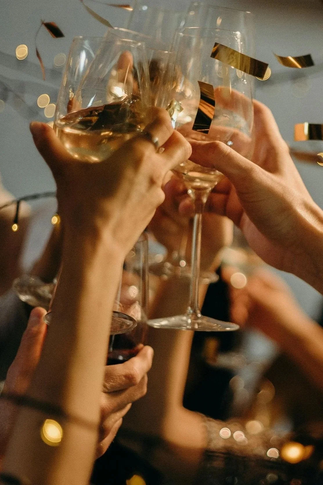Group of people raising glasses for a toast at a celebration event.
