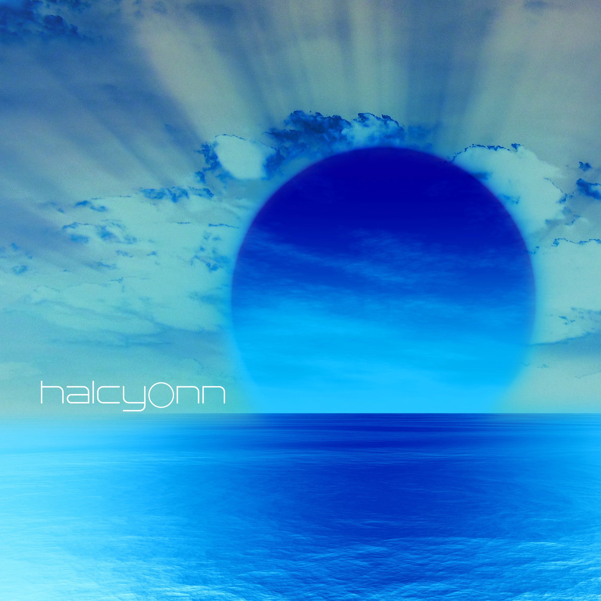 An artistic digital image of the sky and sea, featuring a large, dark blue circle resembling an eclipse or celestial body, with rays of light emanating from behind clouds in the background, and the word 'halcyonn' in white lowercase lettering in the lower left corner.