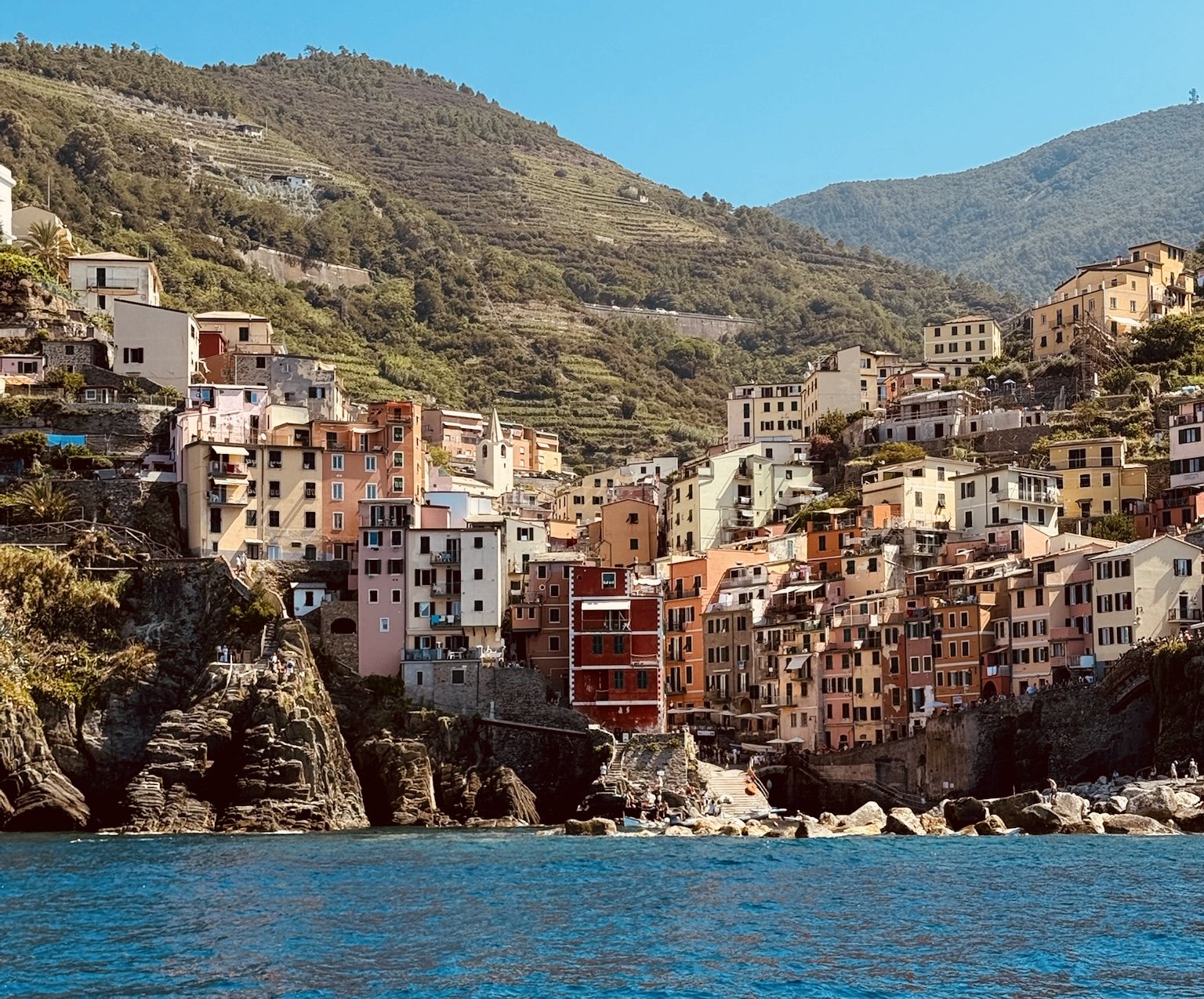 coastal town with mountains in the background with brightly colored houses lining the shore