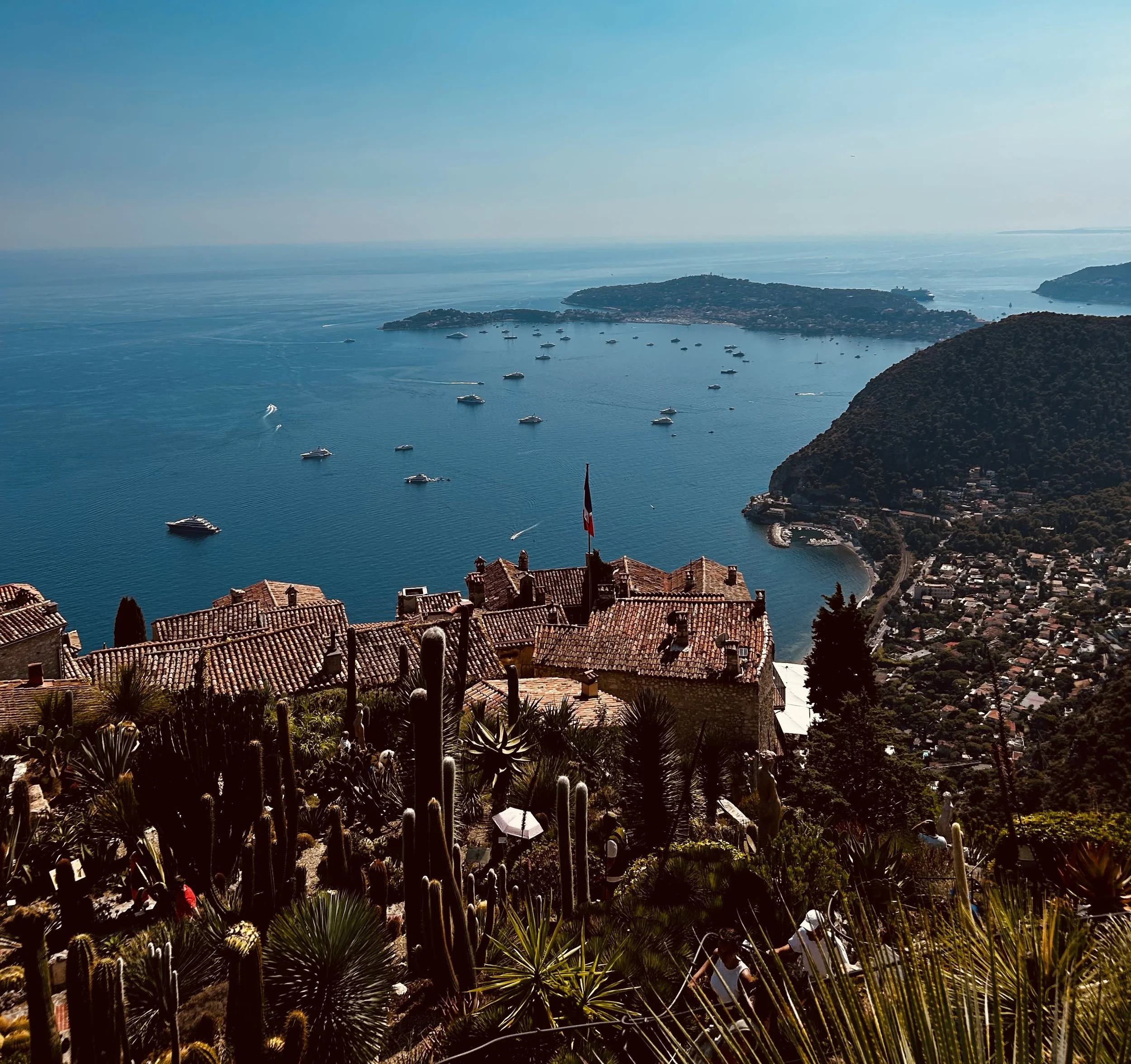 a wide shot of a coastal city with boat doting the water
