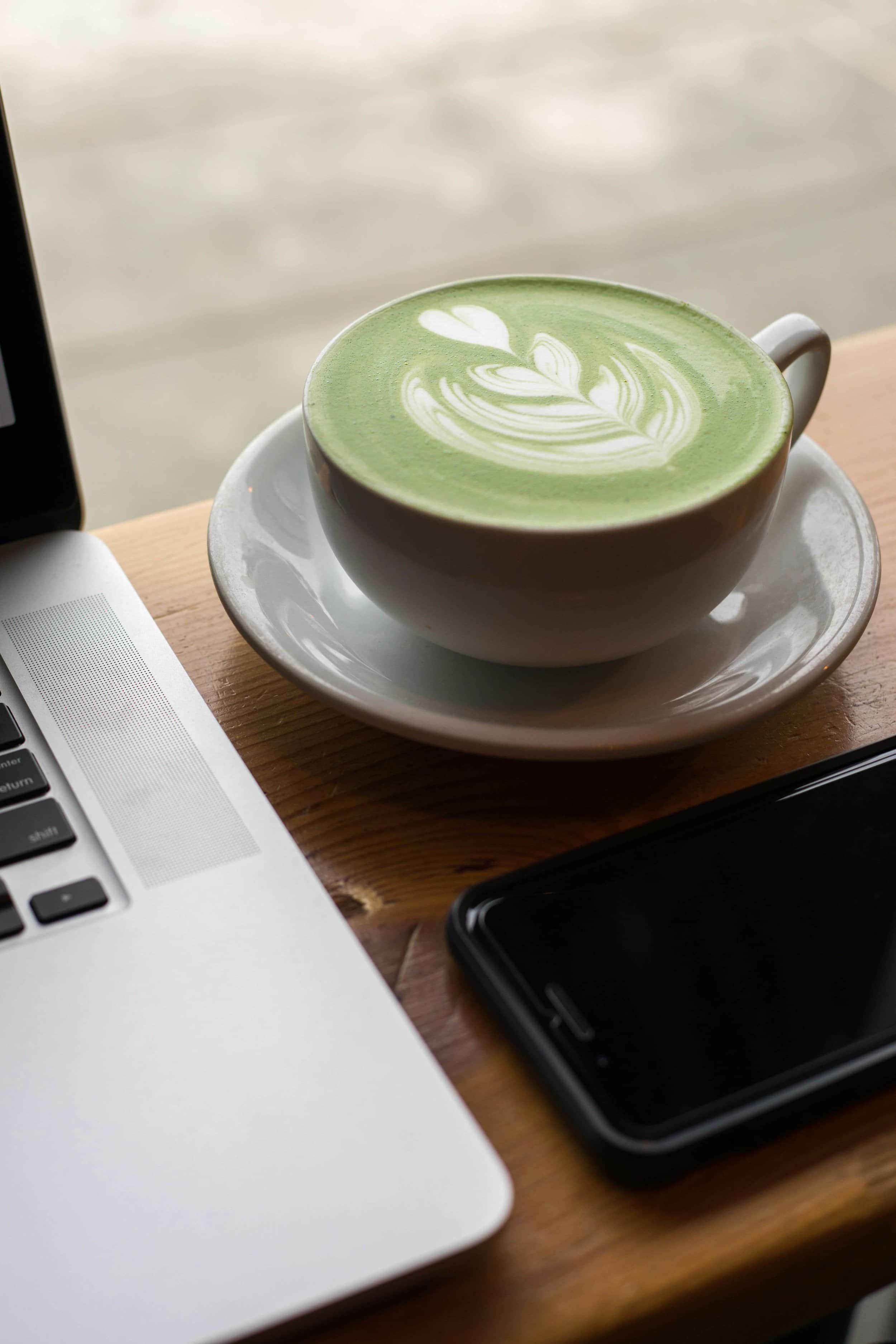 matcha latte, laptop and iphone on a desk