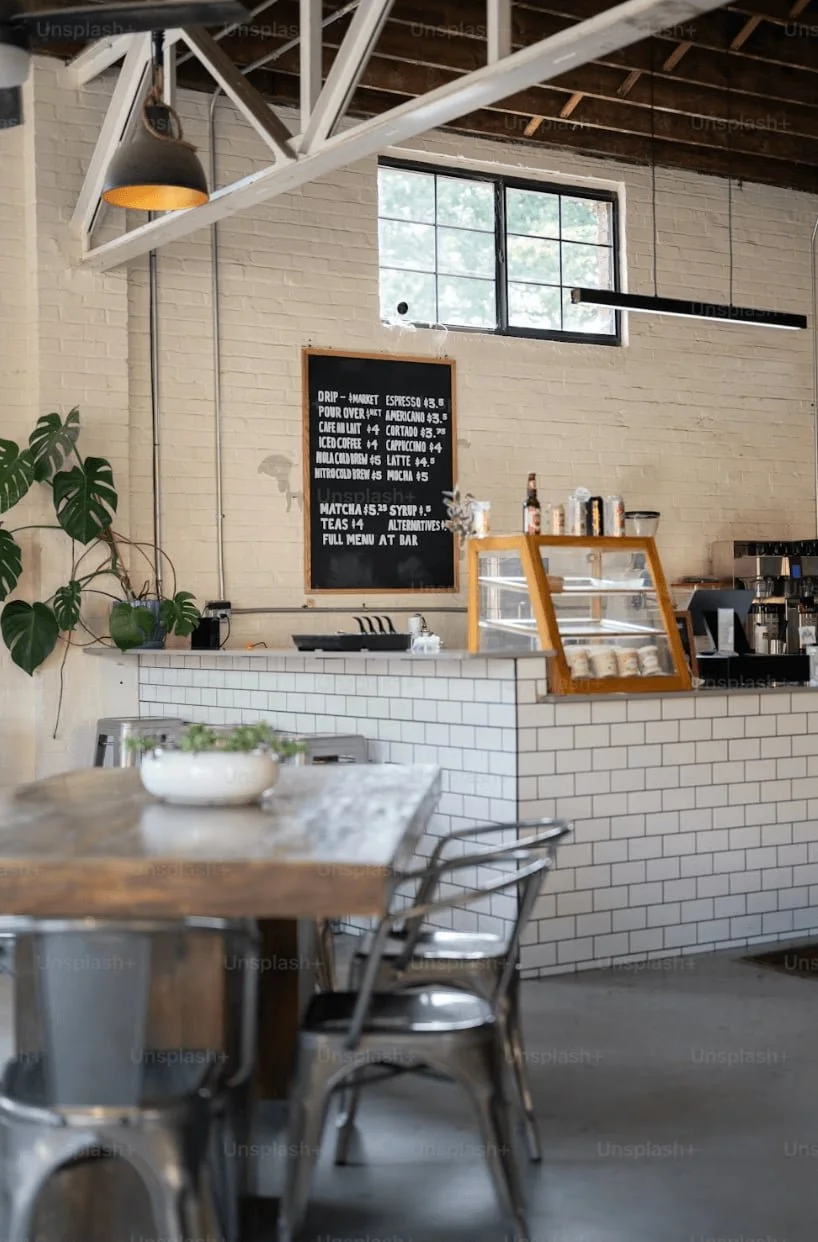 Modern café interior with white subway tiles, metal chairs—perfect meeting space for an Auckland Squarespace website designer and her clients!